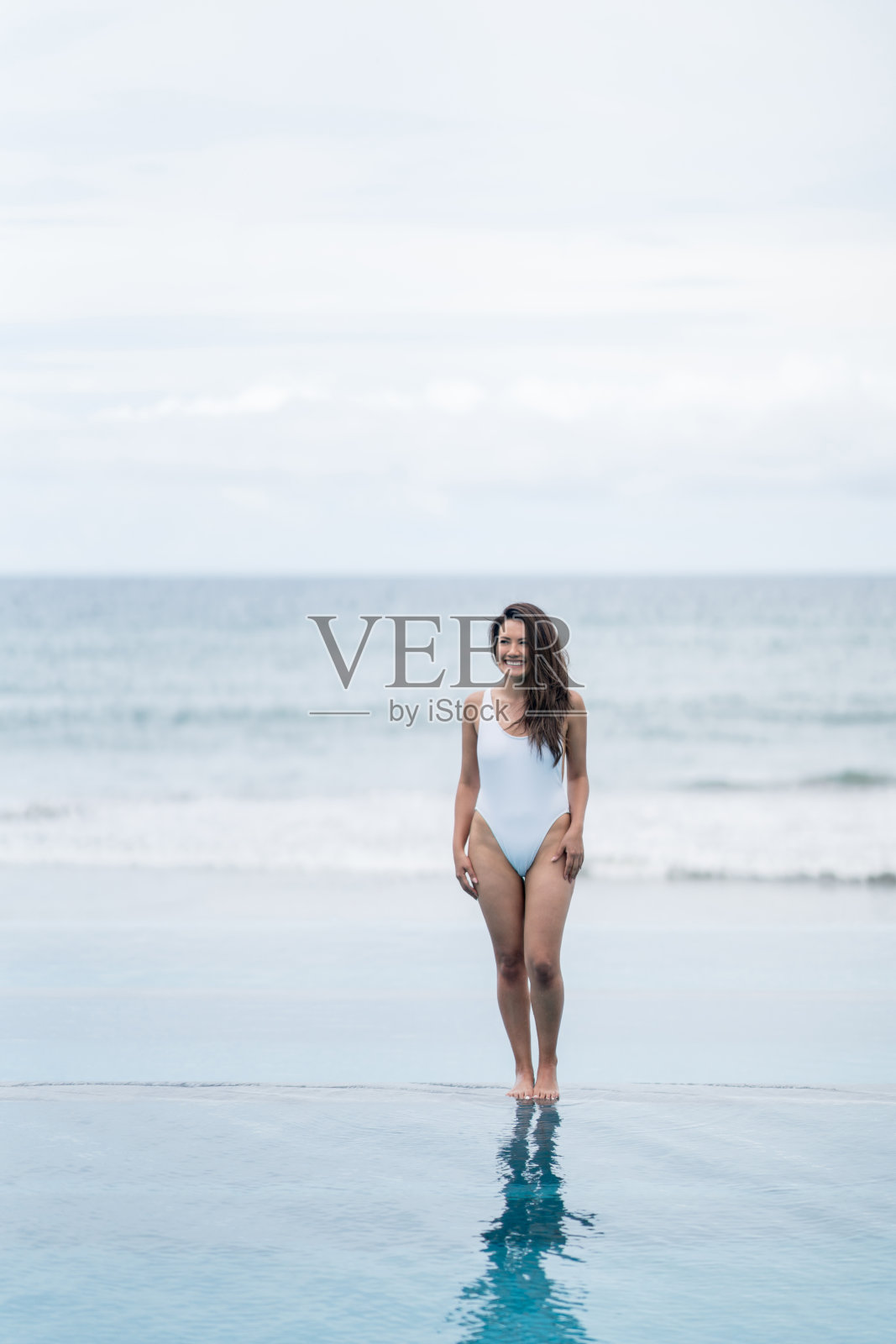 美丽的女人站在无边泳池边照片摄影图片