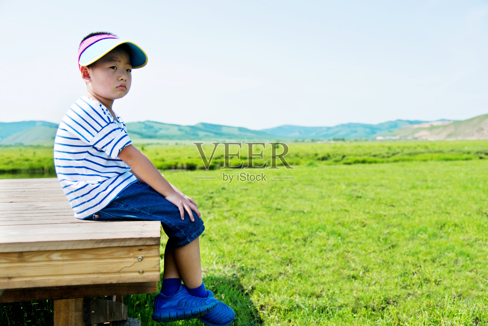 男孩独自坐在大自然的甲板上照片摄影图片