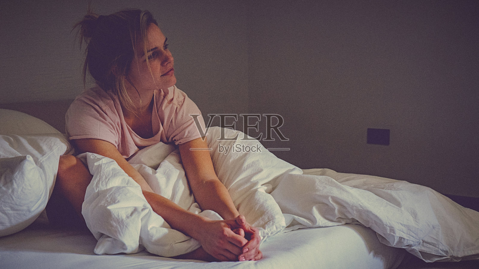 年轻的单身女子早上在家里的床上醒来照片摄影图片