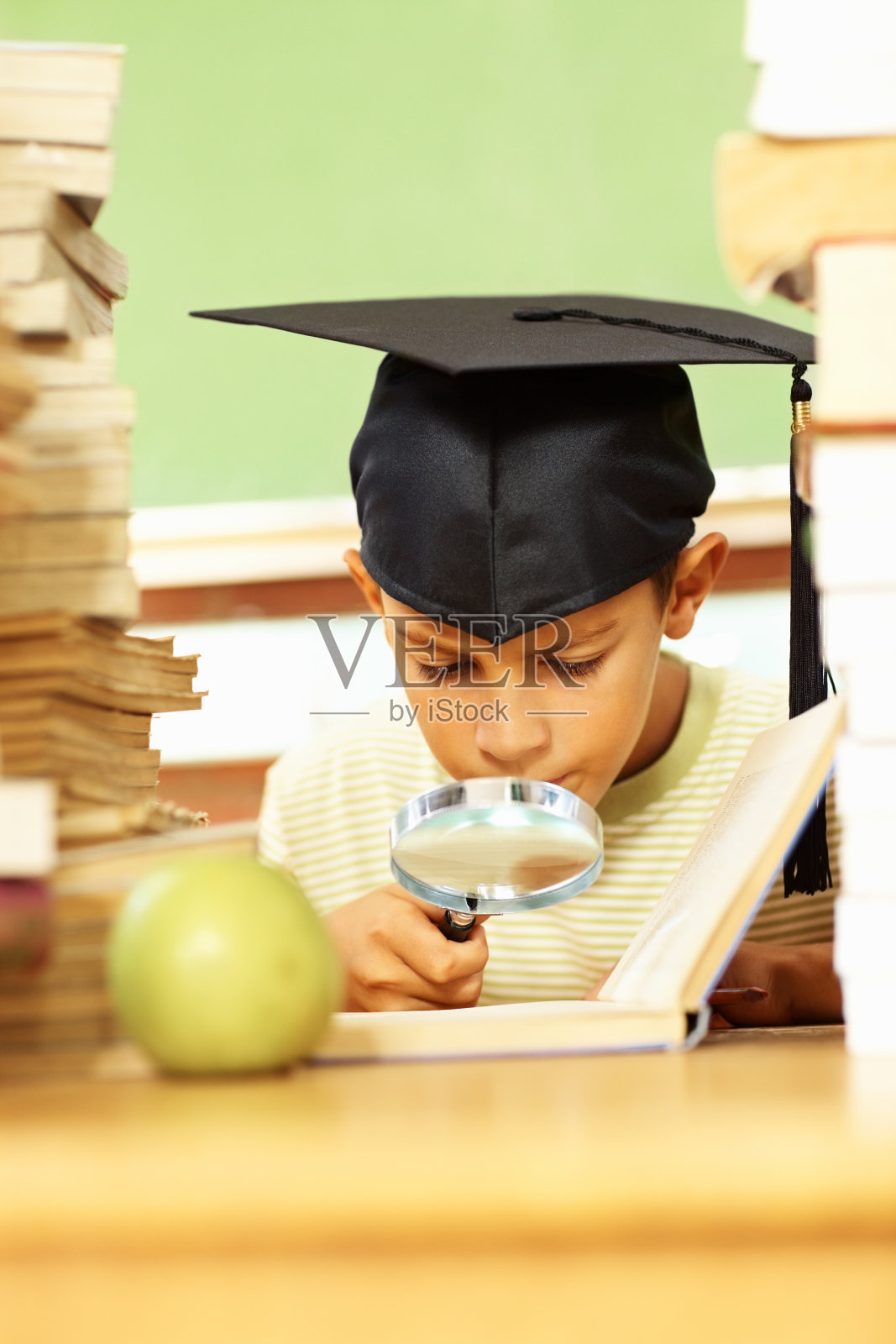 用放大镜看书的男孩照片摄影图片