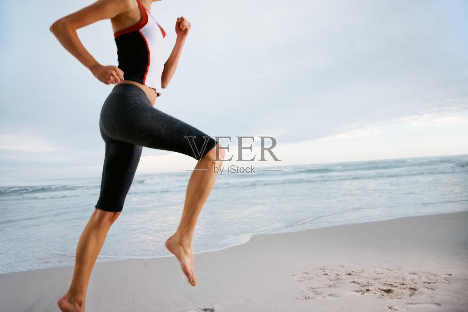裁剪图像的一个女人在海滩上跑步照片摄影图片