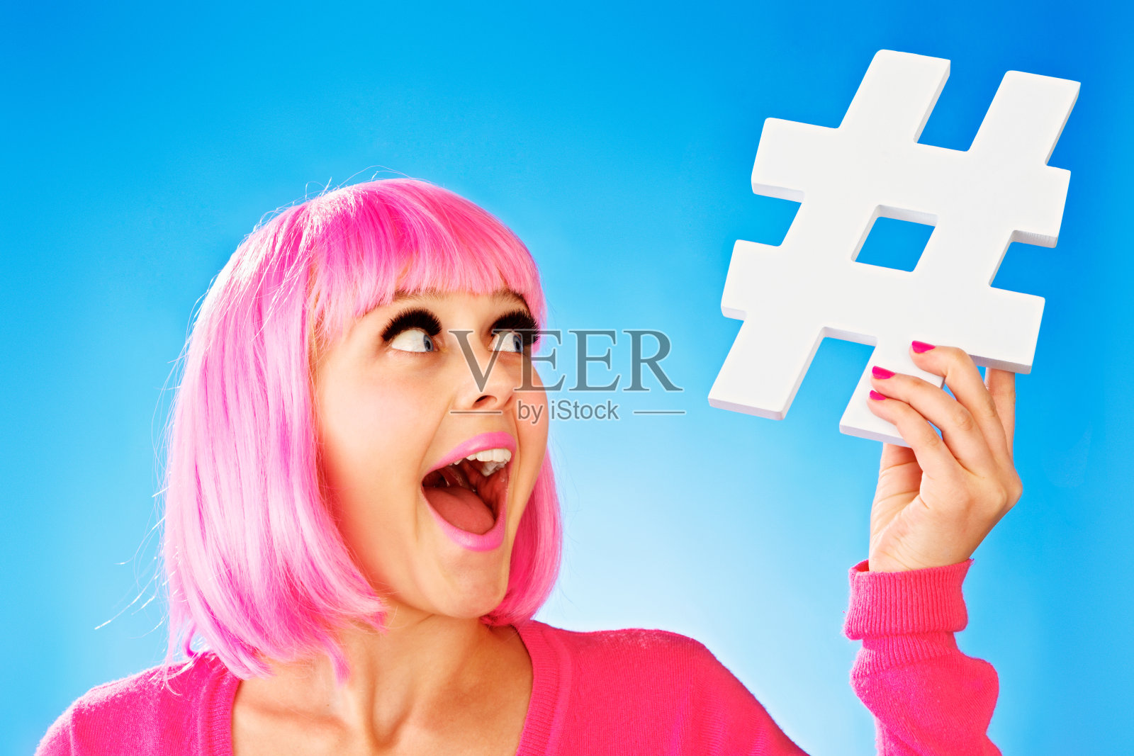 戴着粉色假发的漂亮少年拿着手工制作的标签牌，笑着照片摄影图片