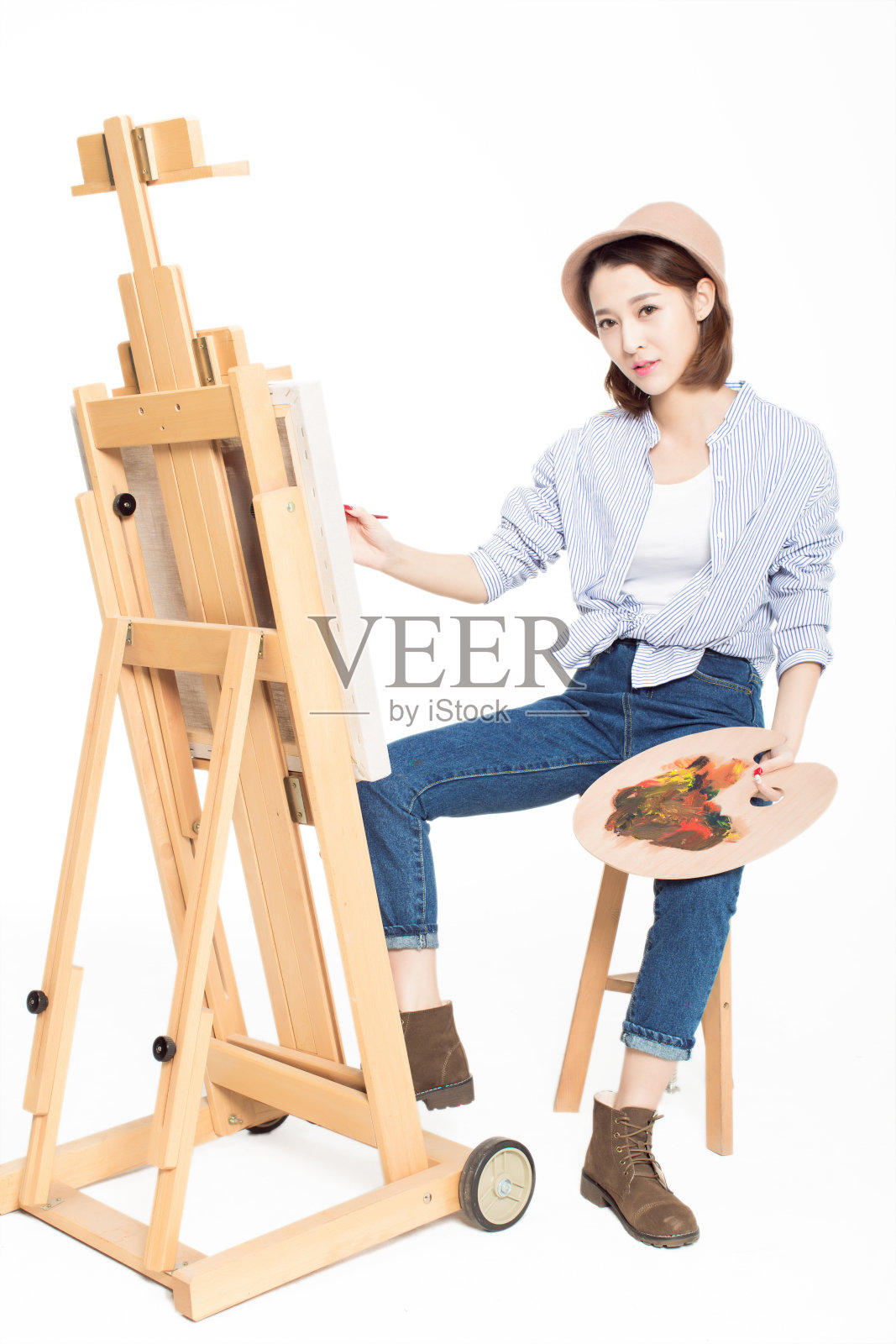 中国画家美丽的女孩，坐在写生板前，拿着调色板照片摄影图片