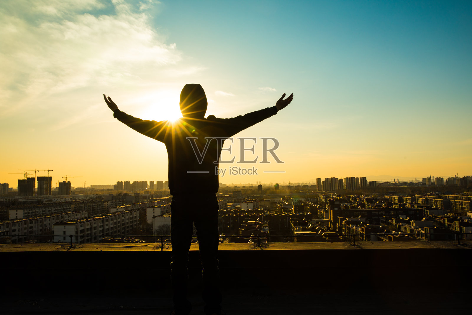 年轻人站在屋顶上，迎接崭新的黎明照片摄影图片
