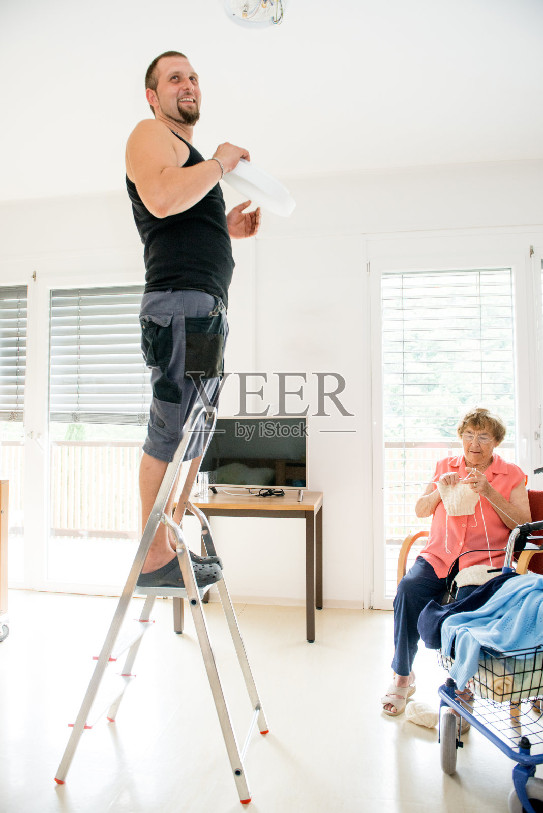 托儿所的维护人员在换灯泡照片摄影图片