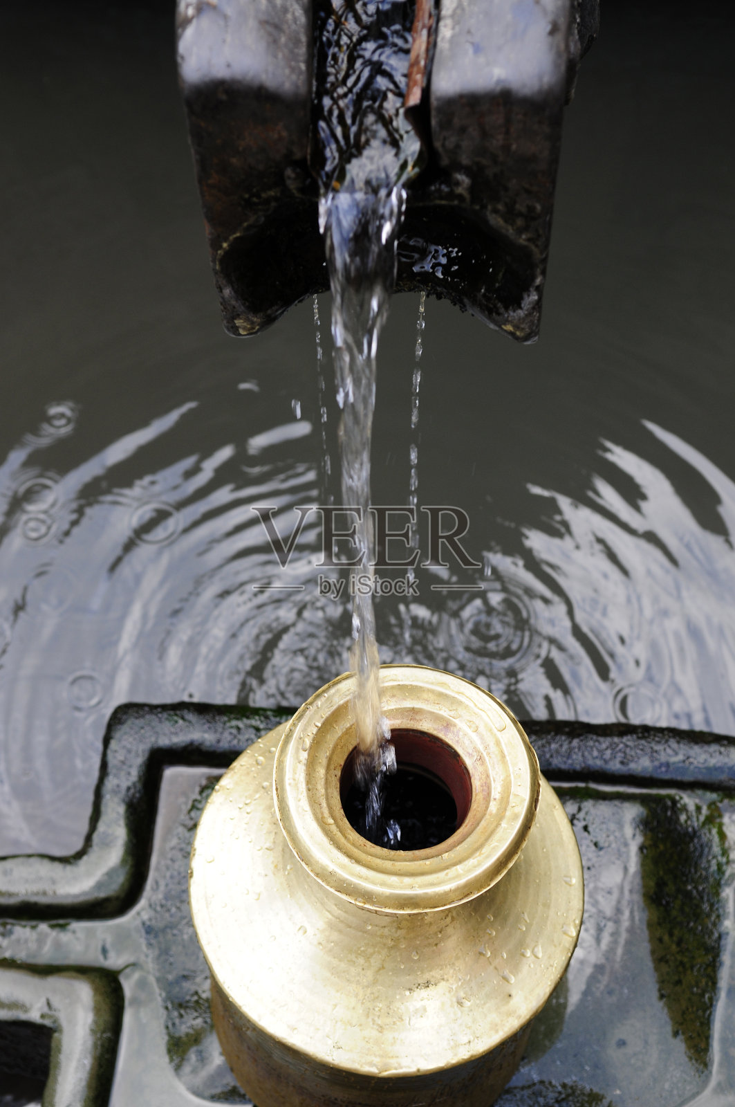 古色古香的石制泉水管和锡罐照片摄影图片