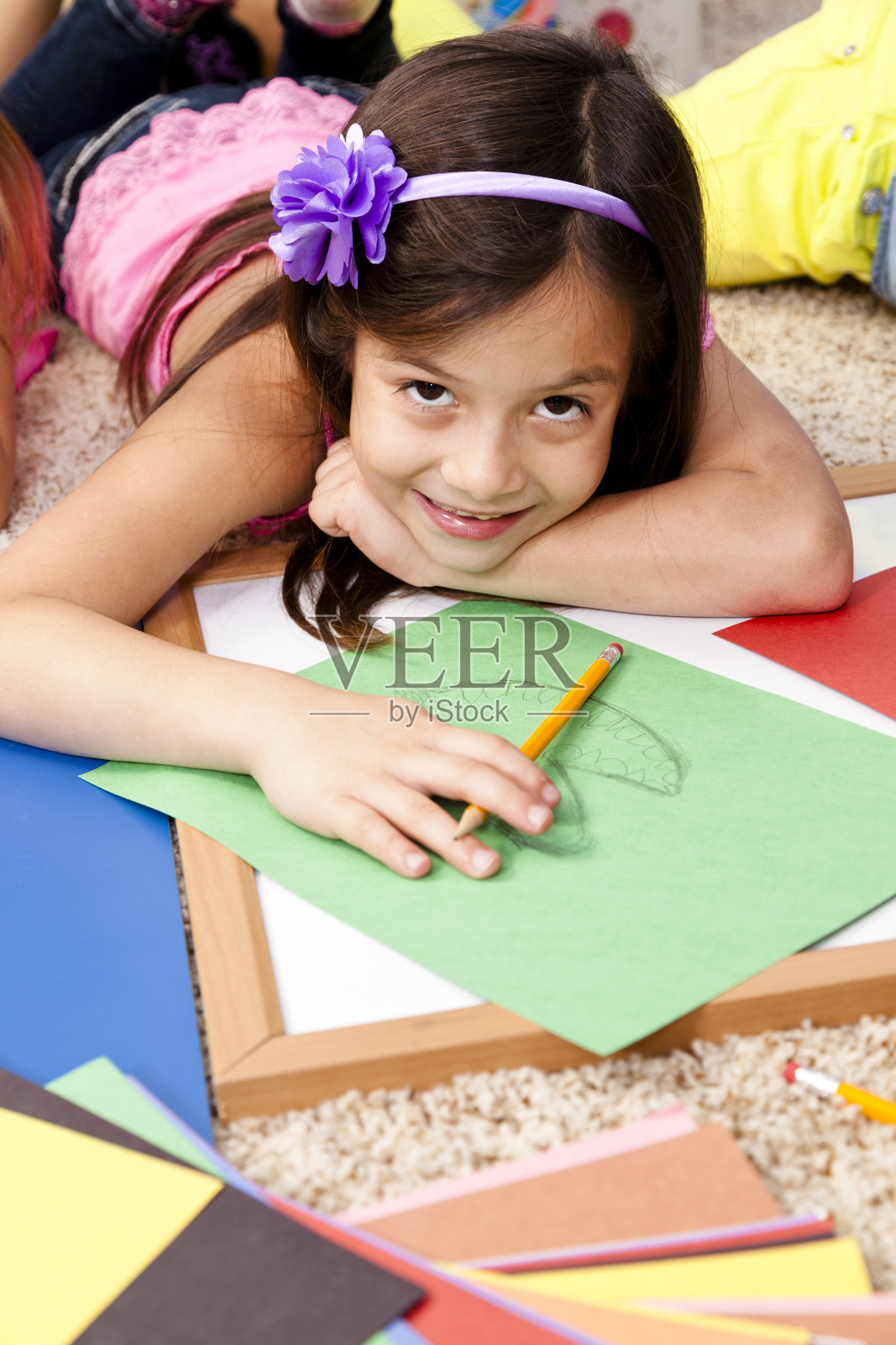 小学女生在教室的地板上写论文照片摄影图片