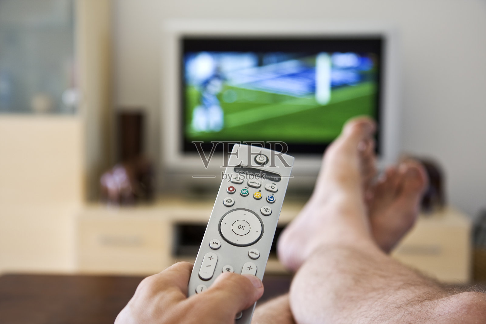 远程控制。懒惰的丈夫看体育。照片摄影图片