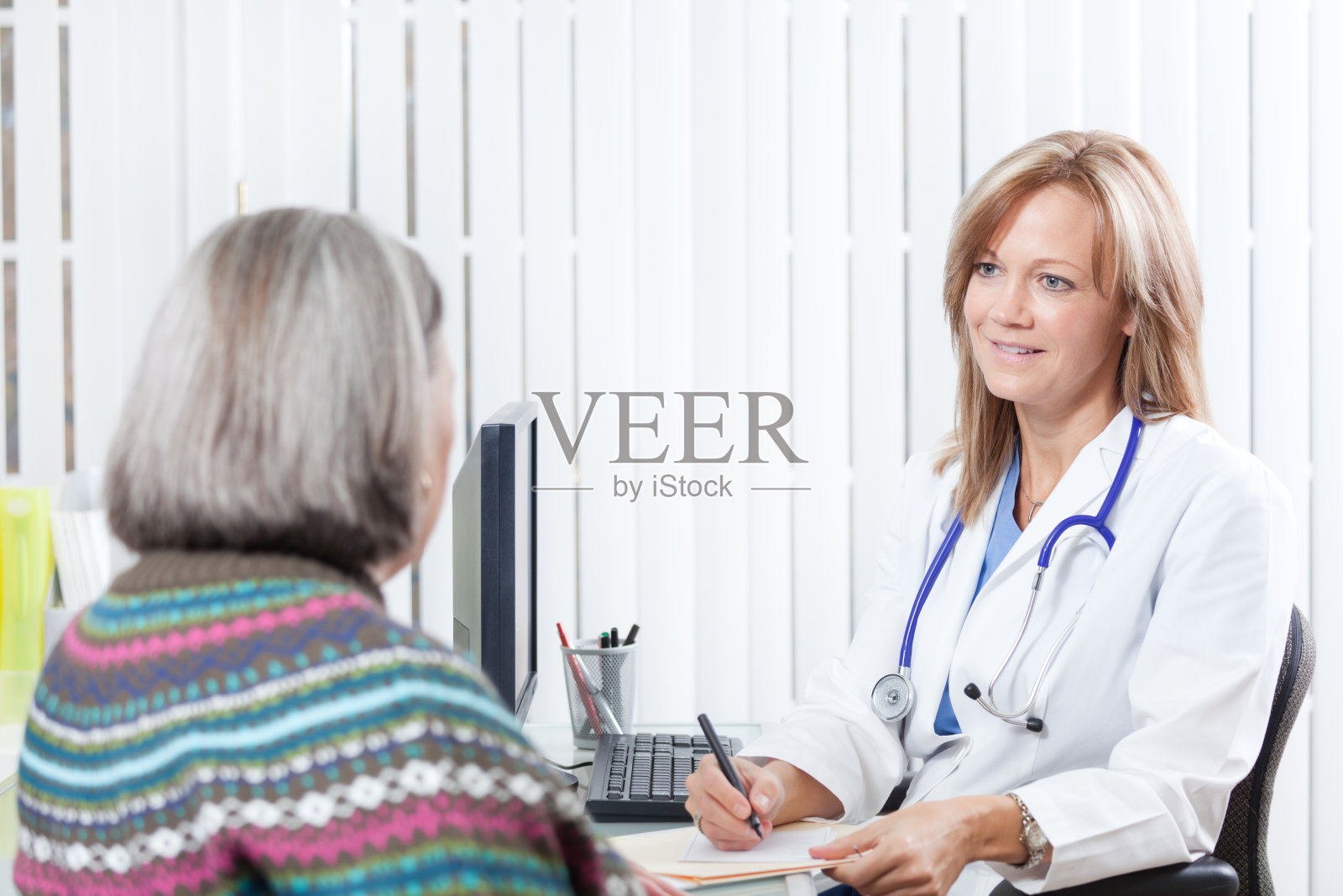 医师在临床Hz中审阅老年病人的病历照片摄影图片