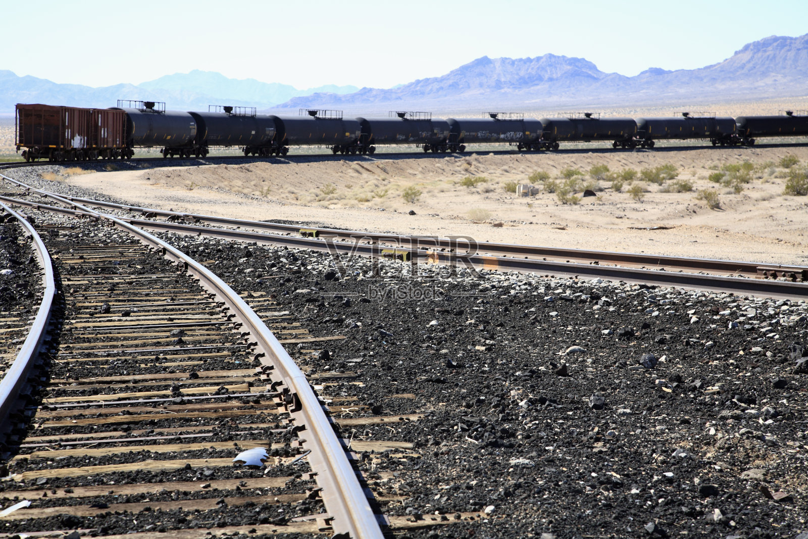 荒凉的沙漠风景与铁路轨道和燃料箱照片摄影图片
