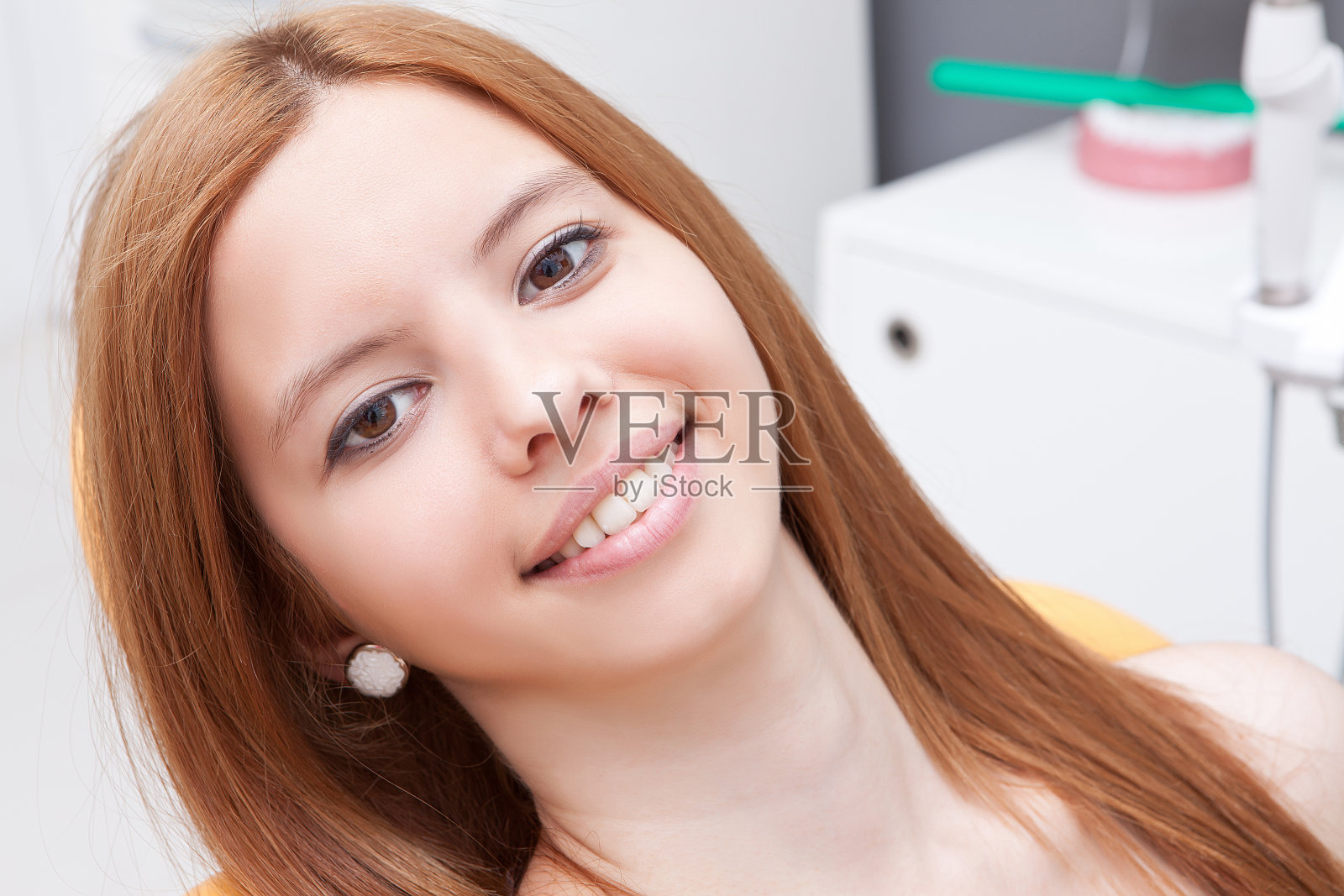 年轻女孩坐在牙医椅上照片摄影图片