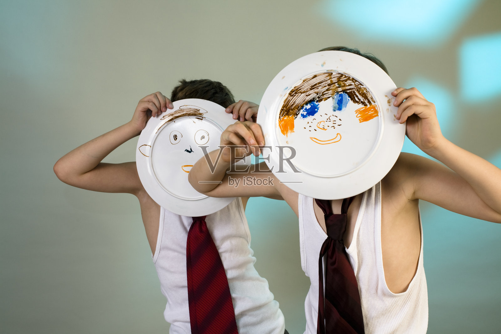 两个男孩穿着汗衫打着领带，脸是纸做的照片摄影图片