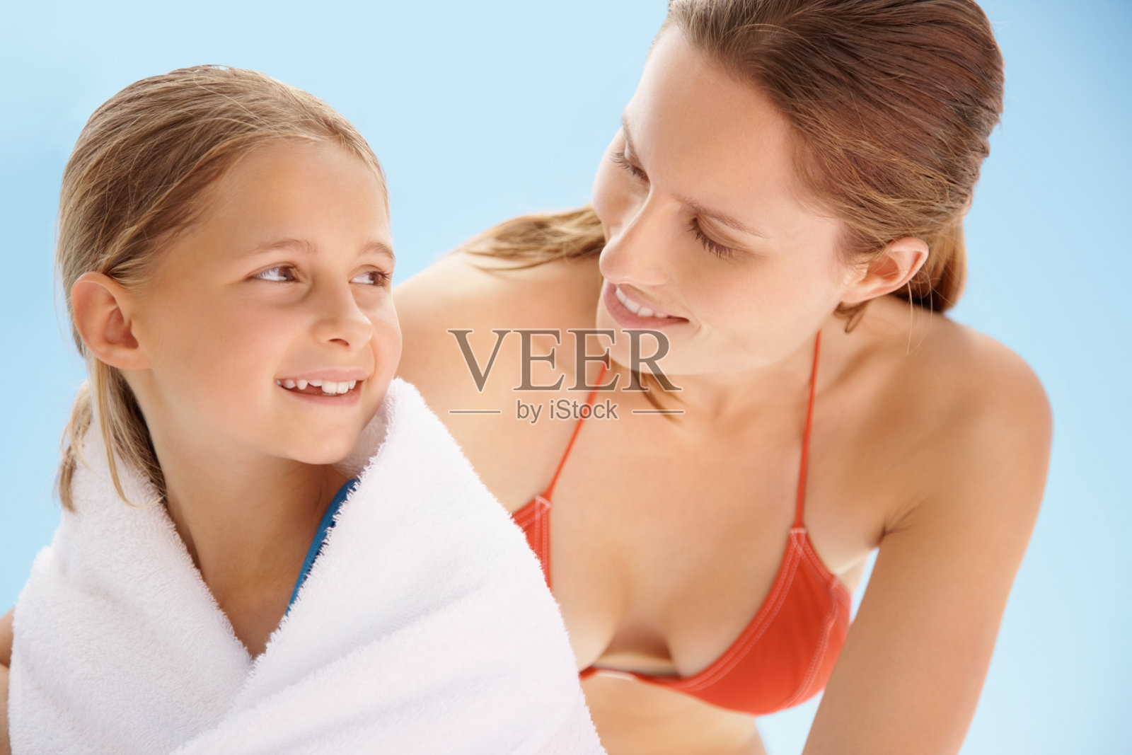 游泳后，母亲用毛巾为女儿擦身照片摄影图片