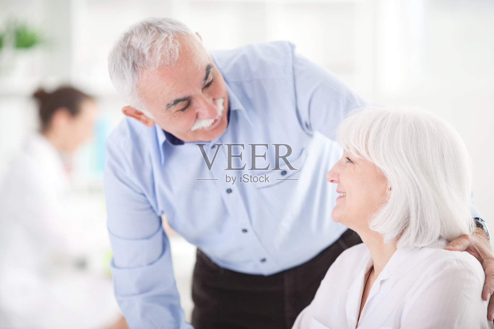 一对老年夫妇在医生办公室。照片摄影图片