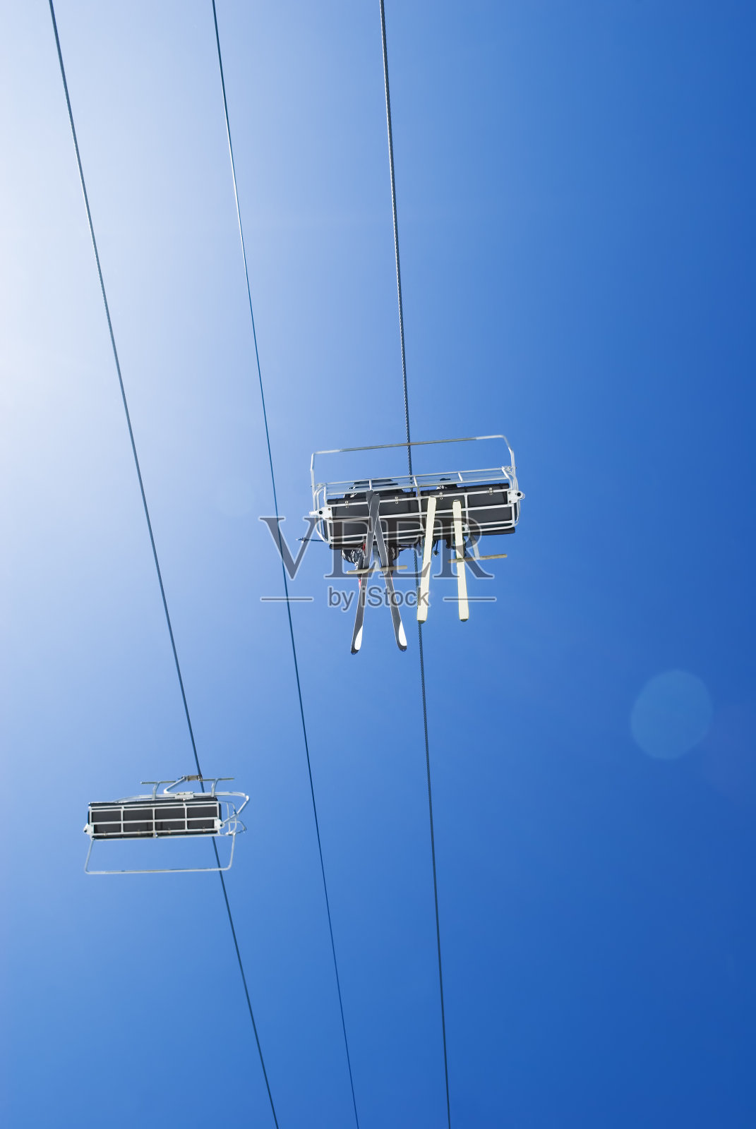 滑雪者在蓝天下乘坐缆车照片摄影图片