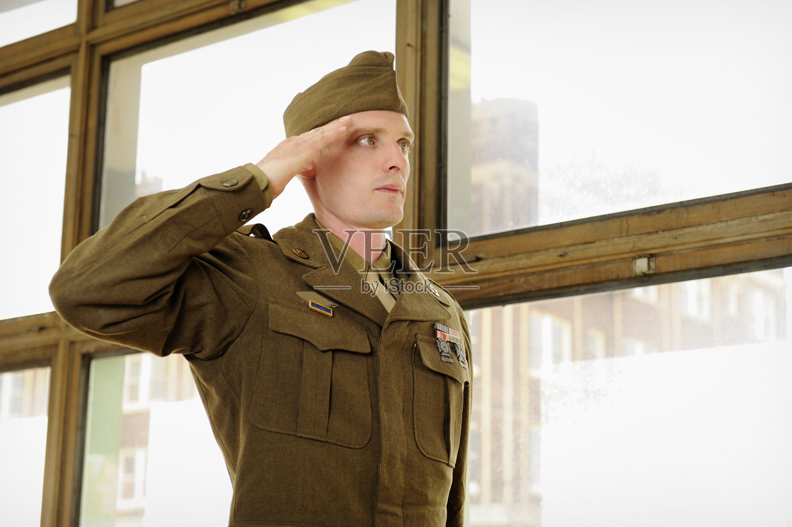 二战老兵在光明的窗户前敬礼照片摄影图片