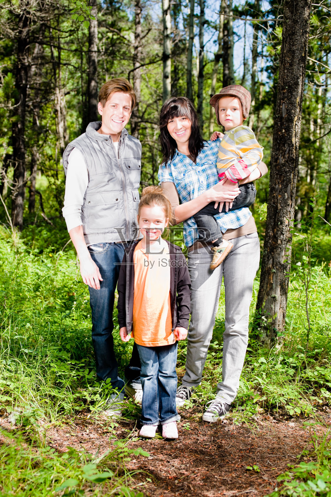 快乐微笑的家庭在绿色夏季森林肖像照片摄影图片