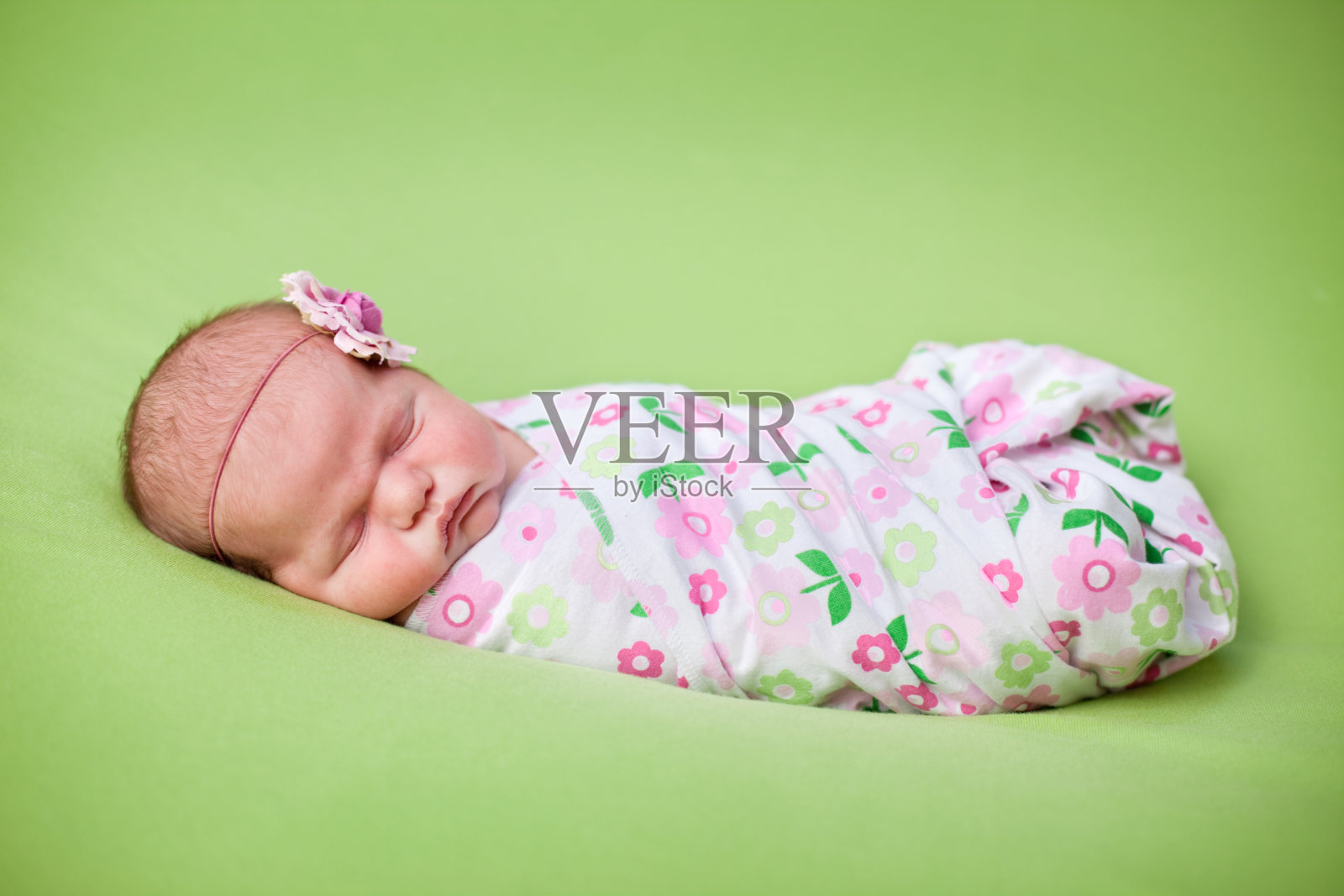 绿色背景下的新生女婴彩色照片照片摄影图片