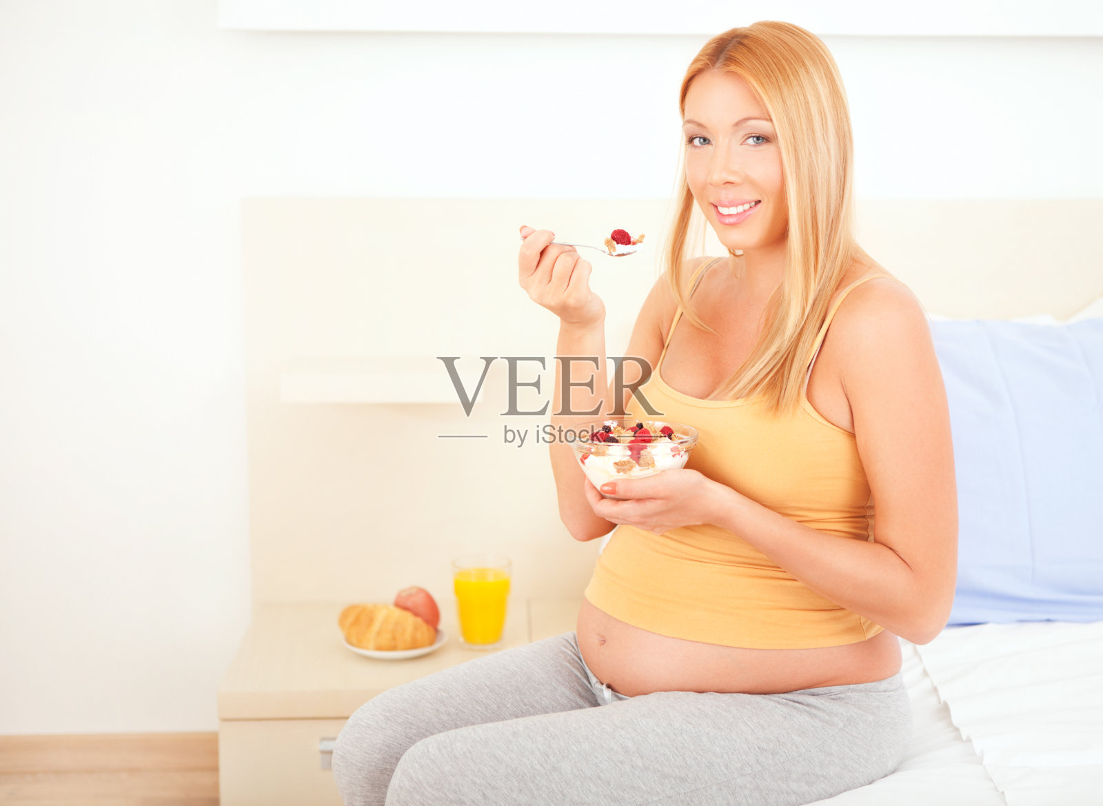 快乐年轻孕妇吃健康食品。照片摄影图片