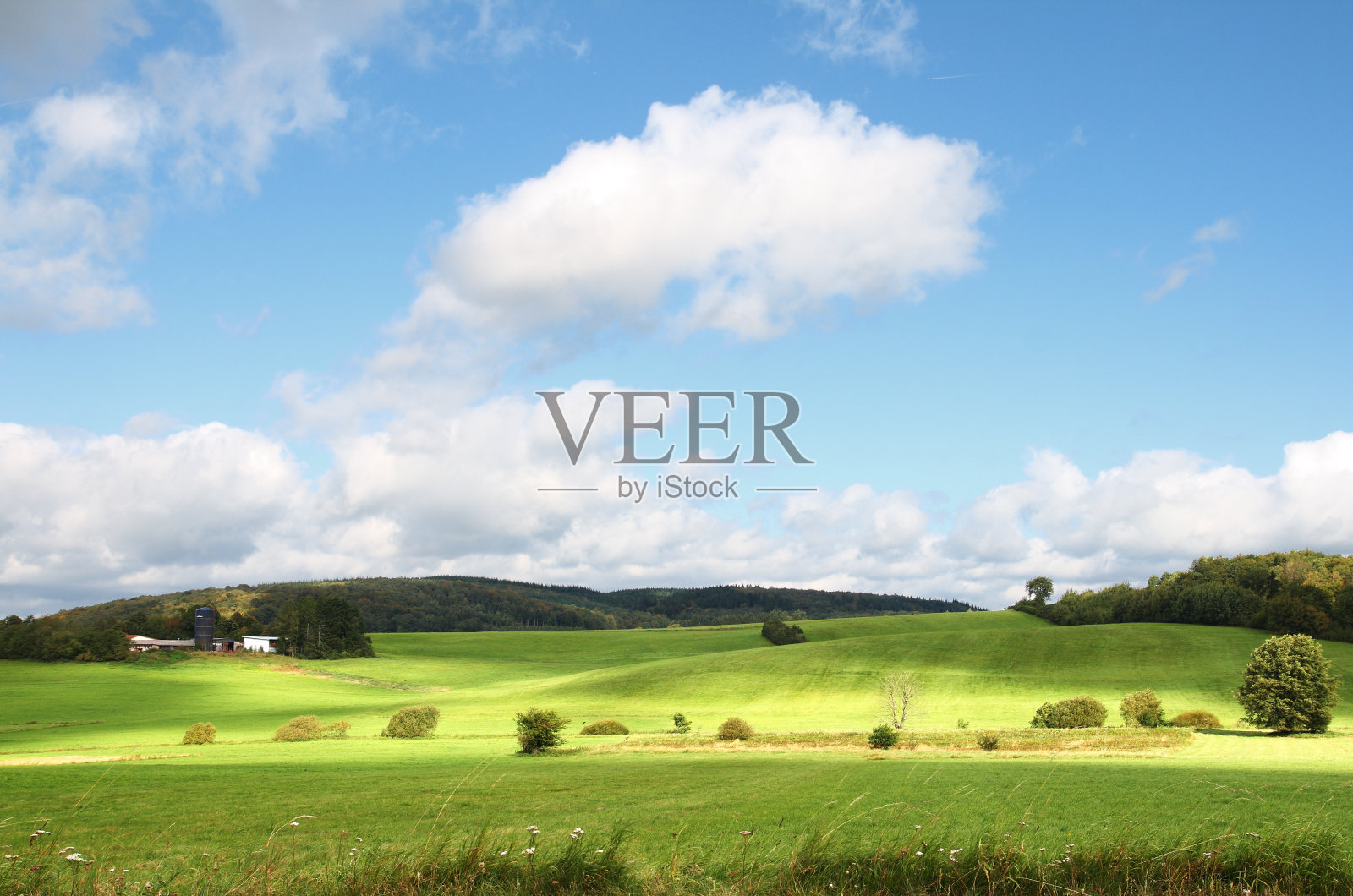 蓝天下丘陵地带的小农场照片摄影图片