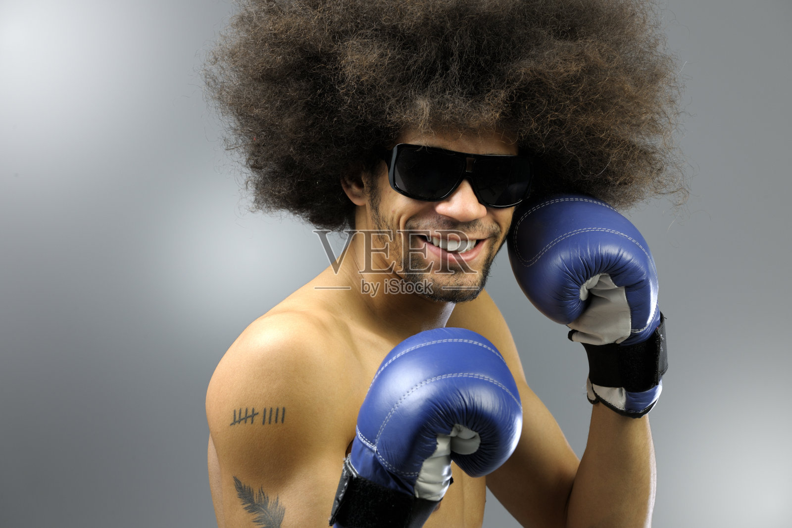 一个留着大爆炸头的微笑男人准备打拳击照片摄影图片