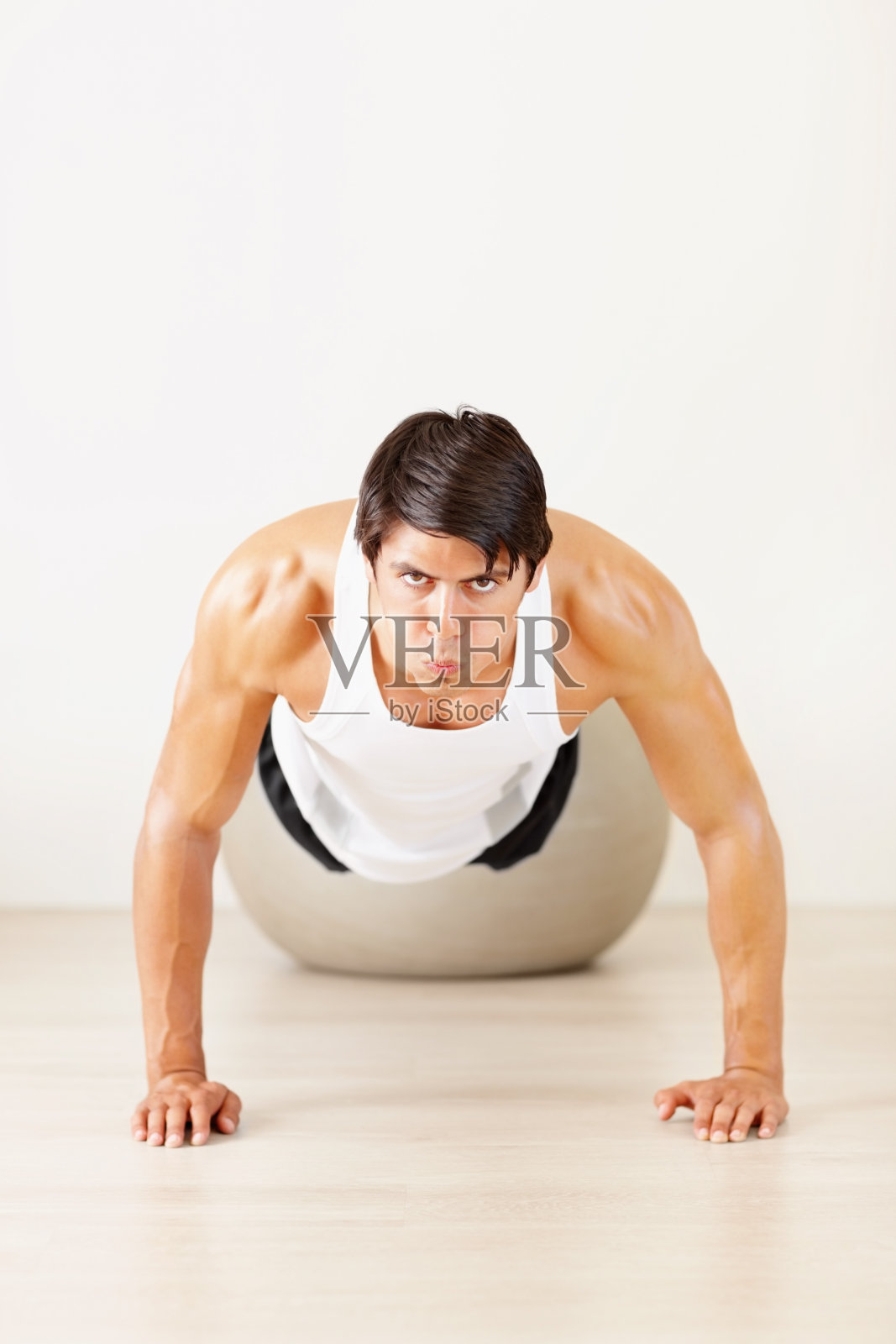 那家伙在健身球上做俯卧撑照片摄影图片