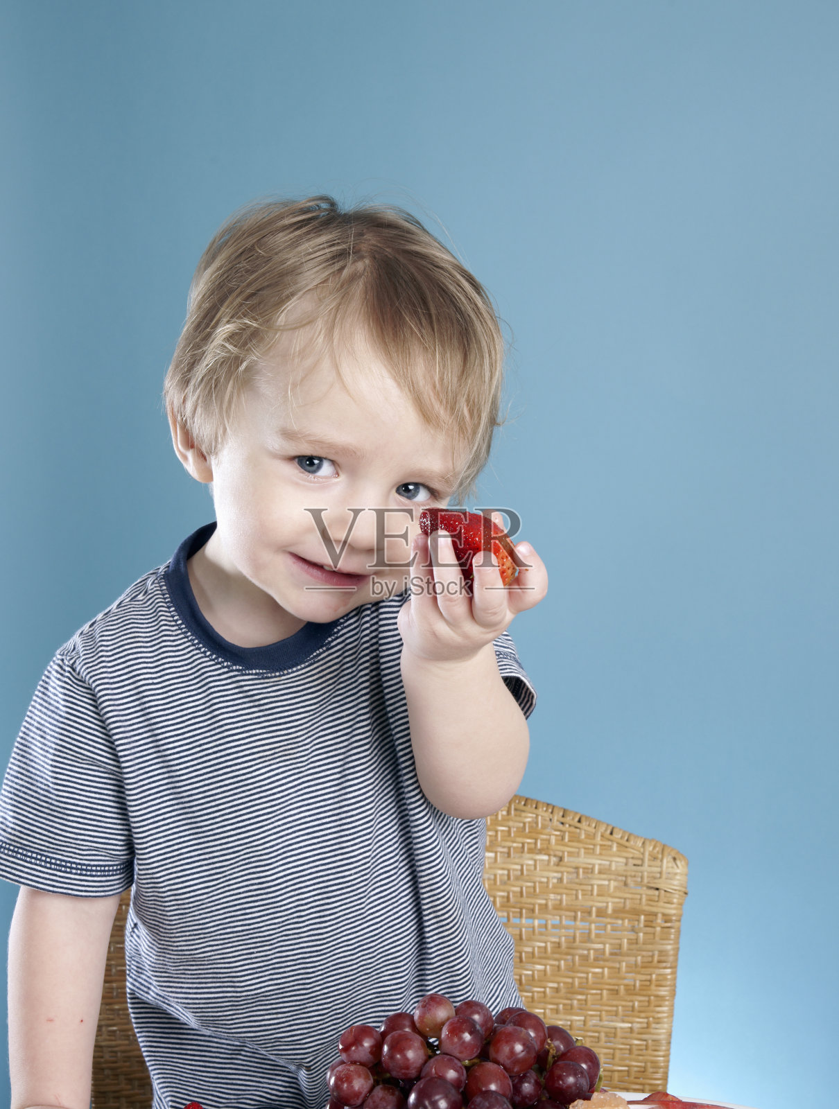 小孩拿着草莓照片摄影图片