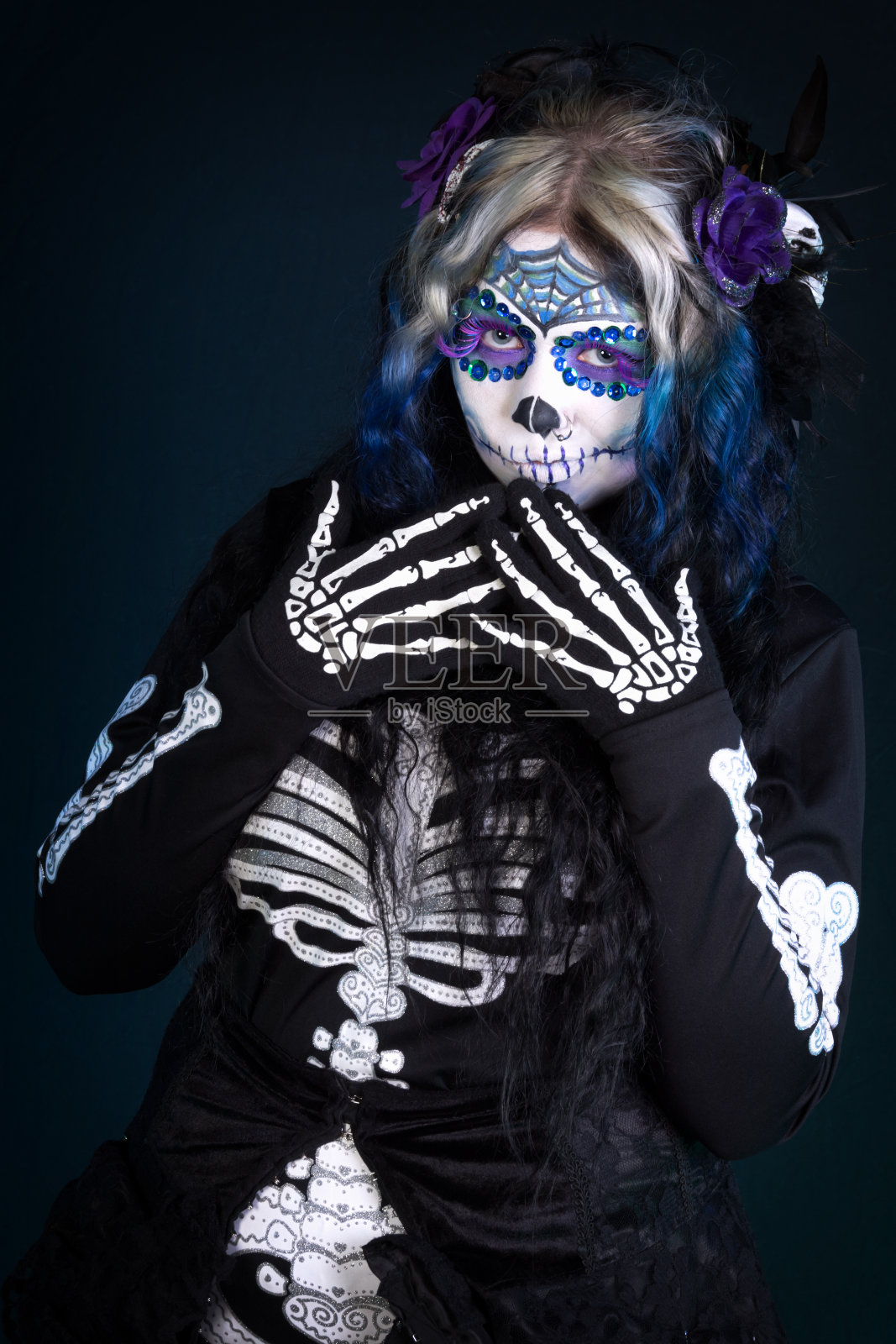 穿着骷髅妆和骷髅装的女人。照片摄影图片