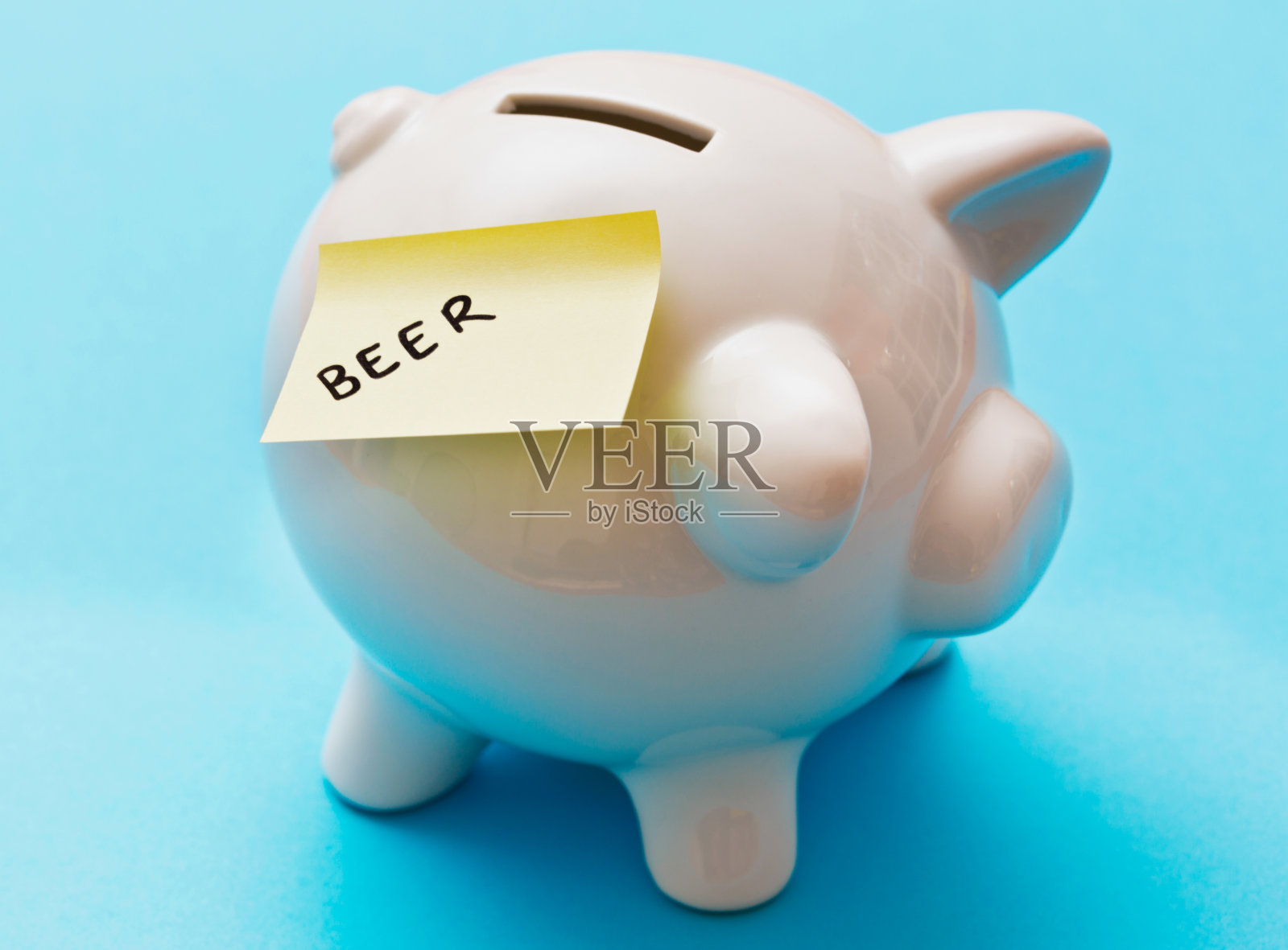 猪储钱罐上的标签上写着啤酒。值得拯救!照片摄影图片