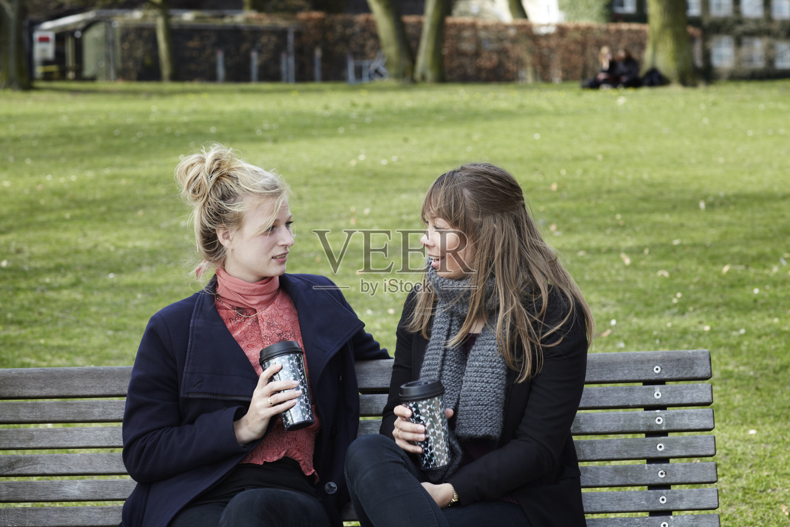 两个女大学生坐在公园里喝咖啡照片摄影图片
