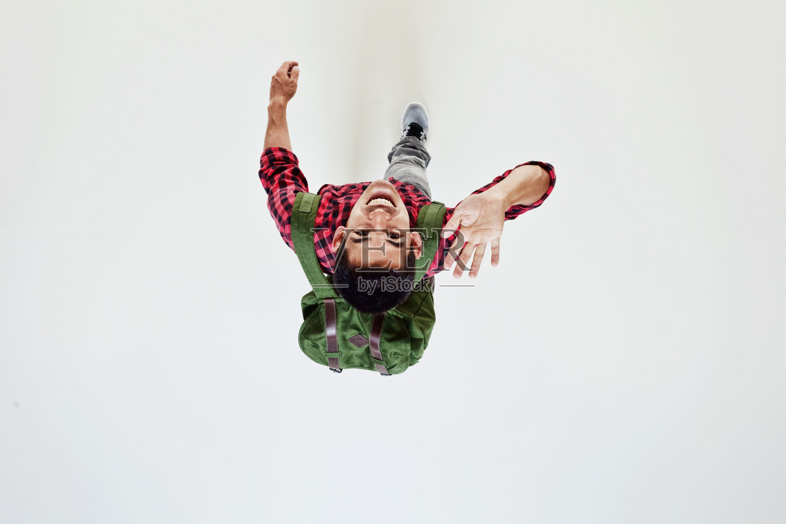 上图为拿着绿色袋子的学生挥手照片摄影图片