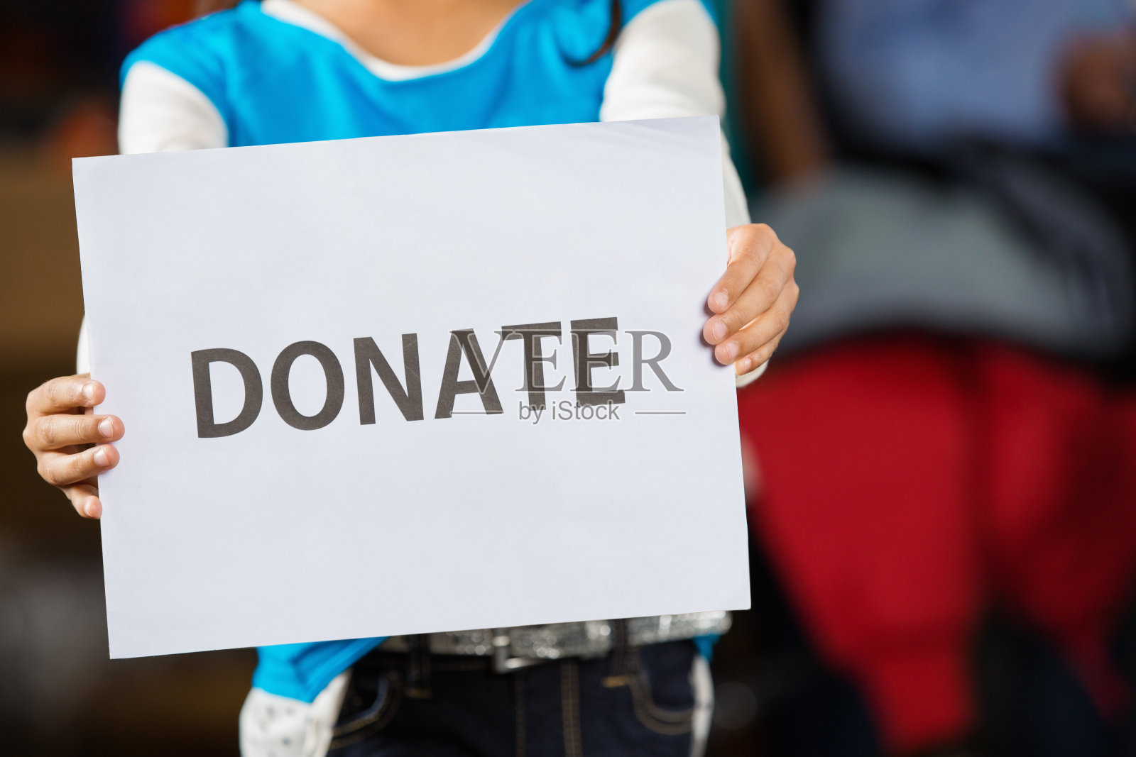 在食品银行，孩子们拿着“捐赠”的牌子照片摄影图片