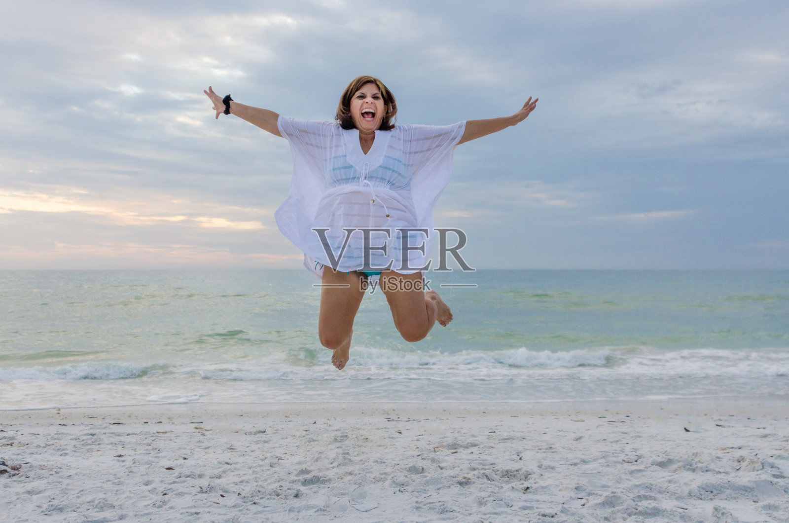 在沙滩上跳跃照片摄影图片