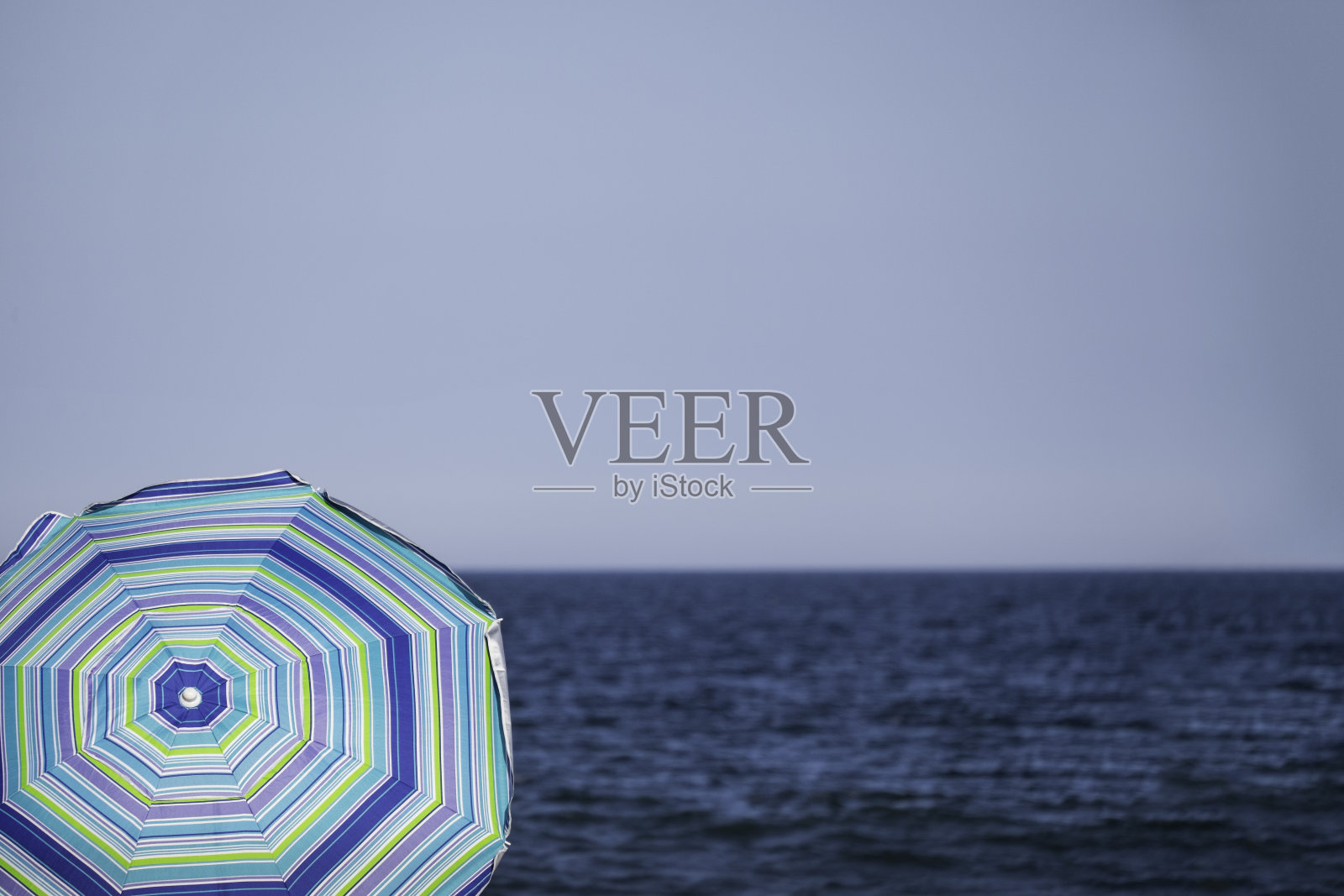 蓝色条纹沙滩伞俯瞰蓝色海洋照片摄影图片