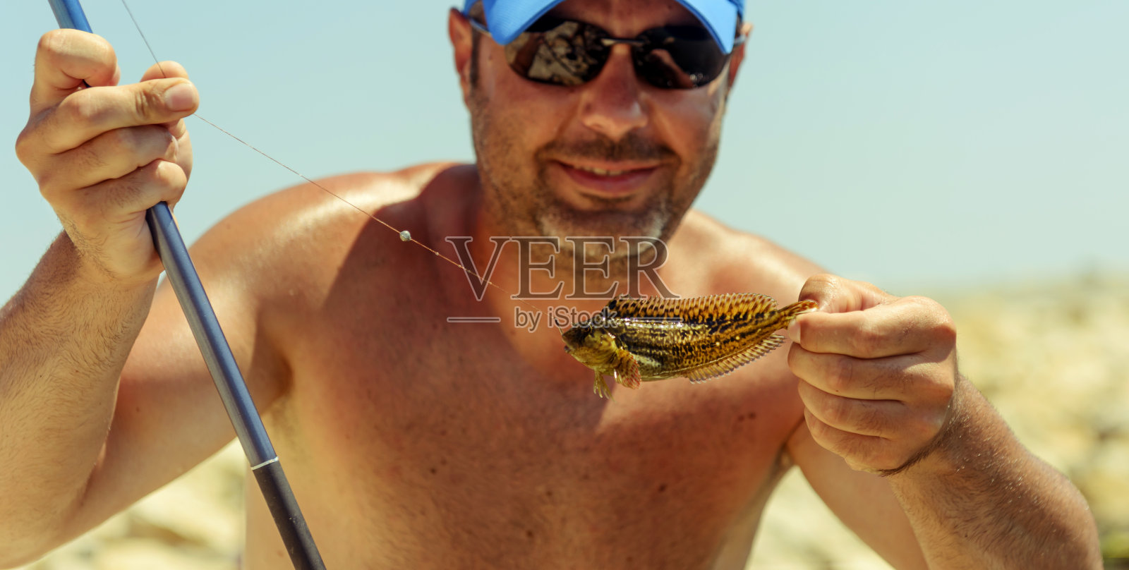 小鱼在男人的手里照片摄影图片