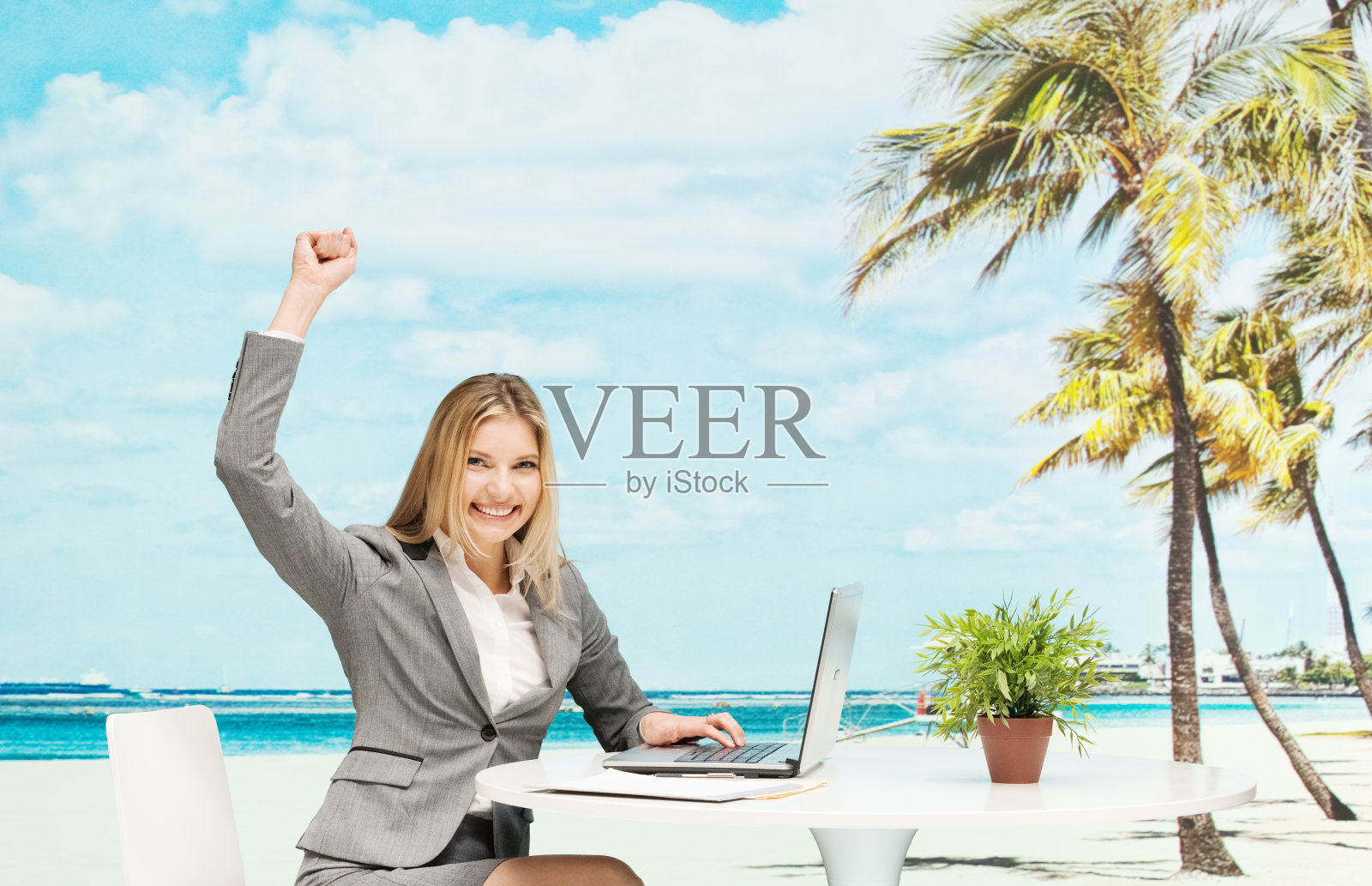 微笑的女商人在海滩上欢呼照片摄影图片