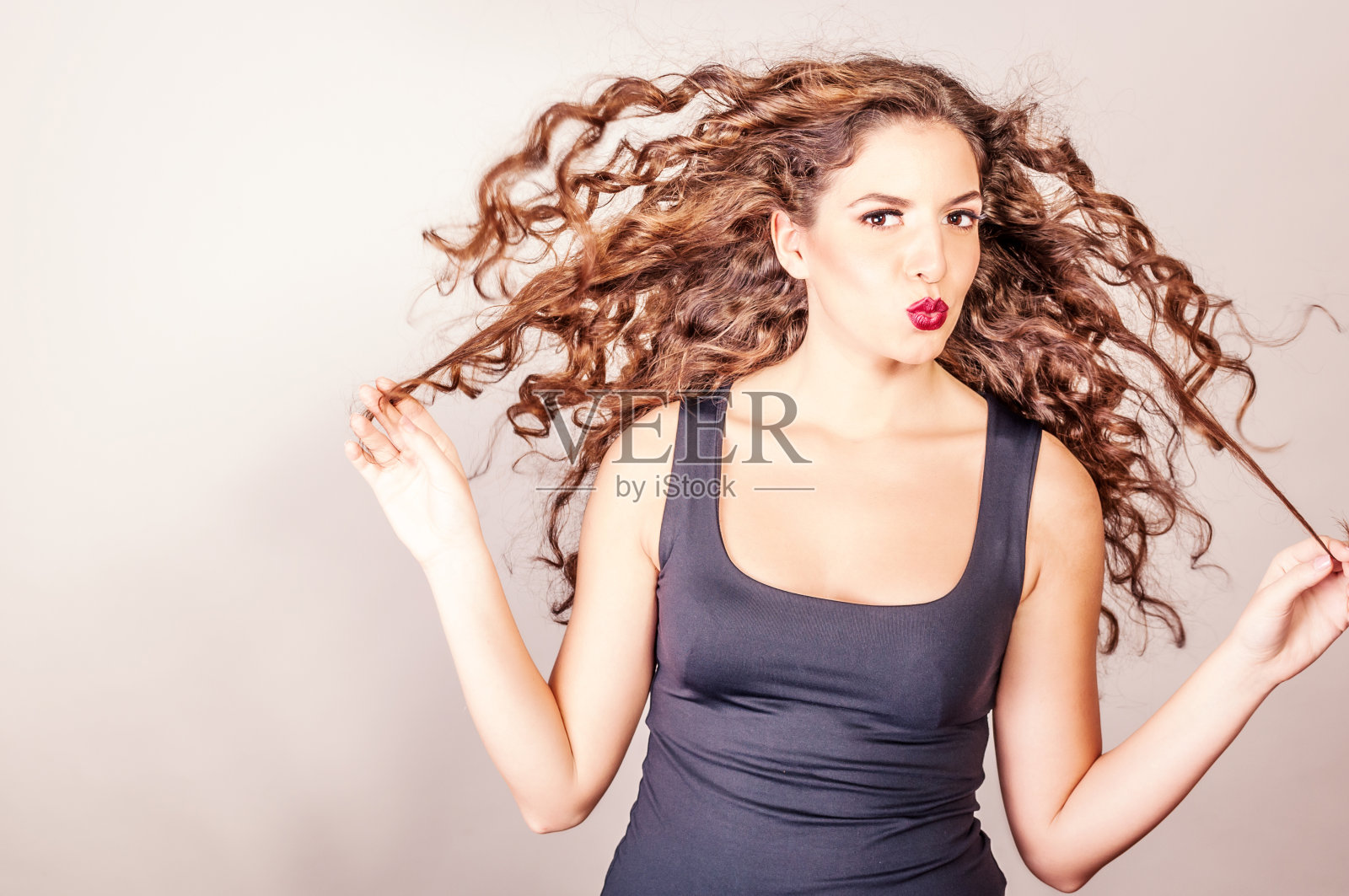 长着一头大卷发的漂亮女人照片摄影图片