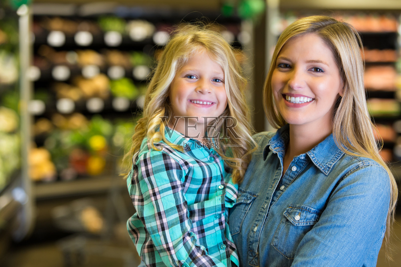 母亲抱着小女孩在杂货店购物照片摄影图片