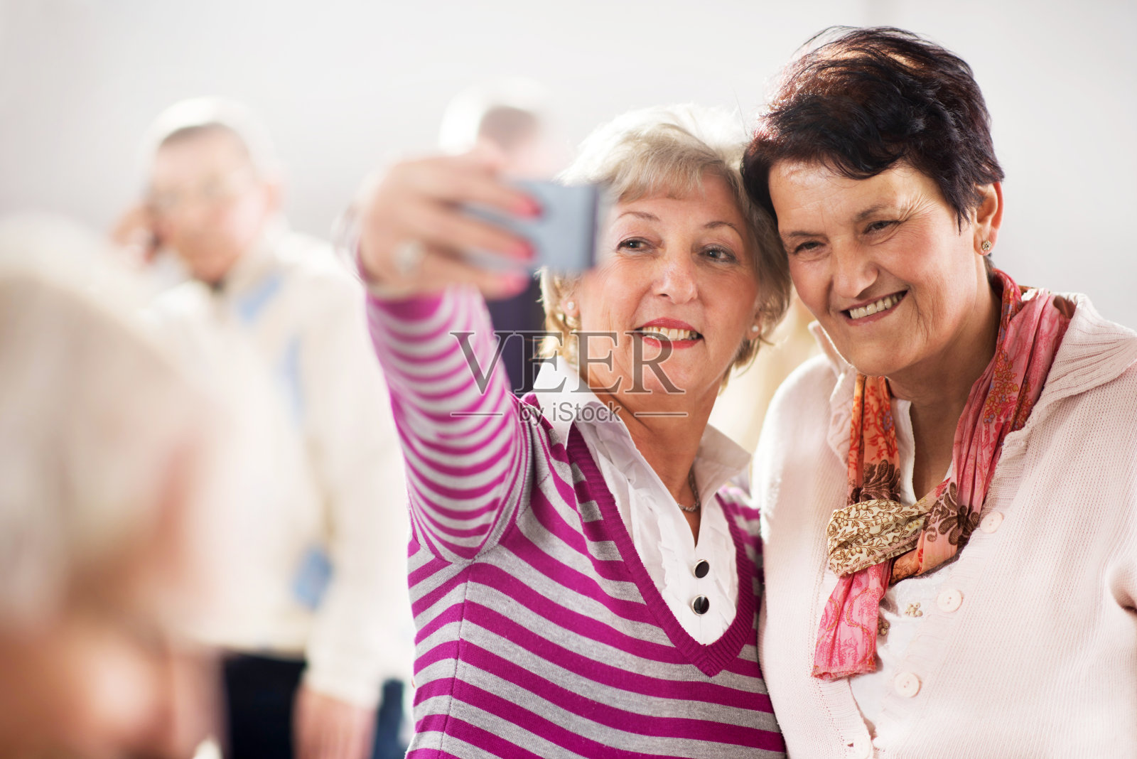 微笑着用手机自拍的资深女性。照片摄影图片