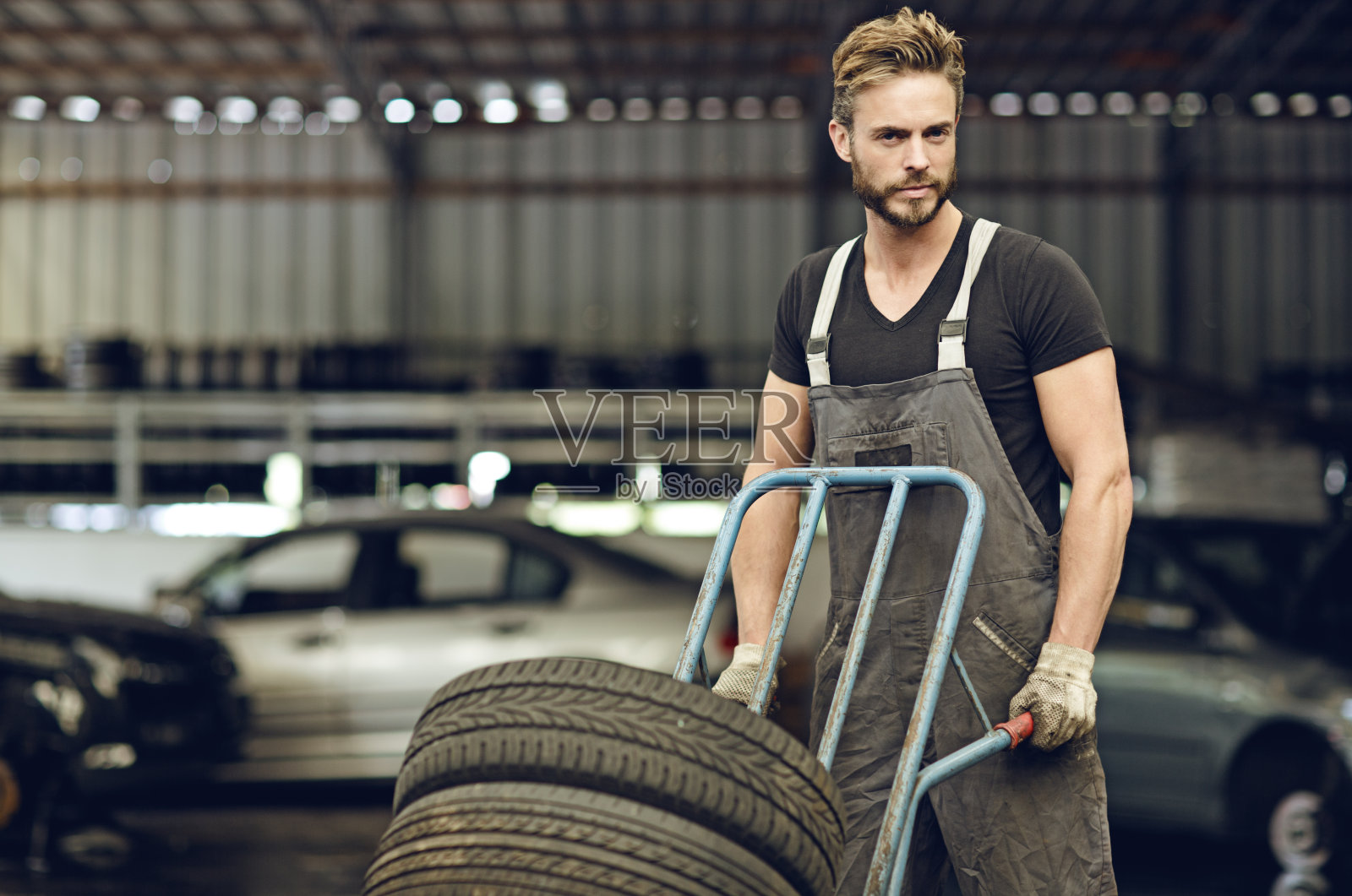 性感的机械师在马车上运送轮胎照片摄影图片