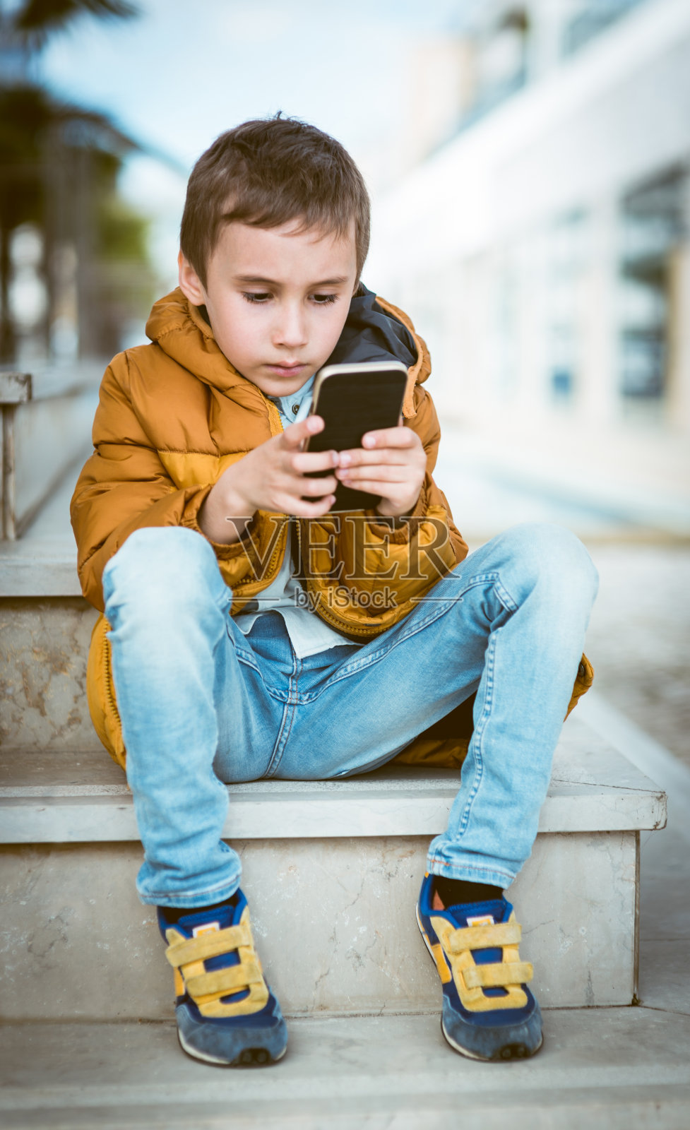 小男孩使用智能手机照片摄影图片