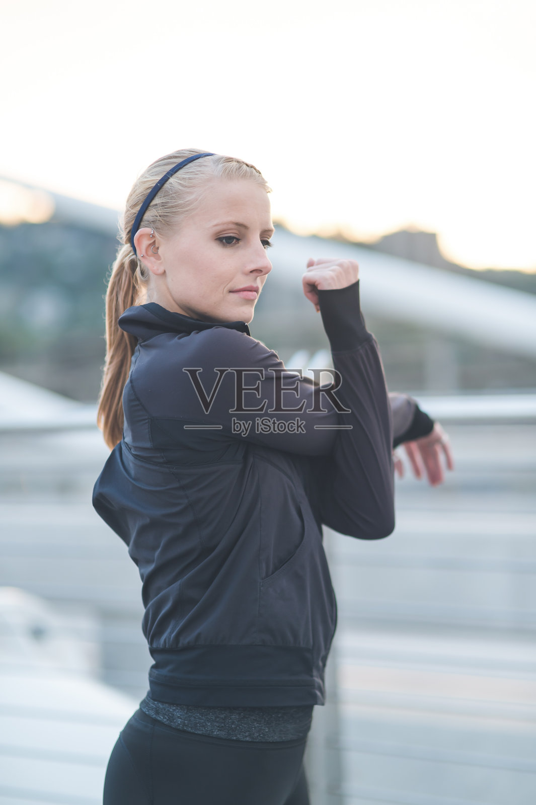 年轻的成年女性在她的城市环境跑步前伸展照片摄影图片