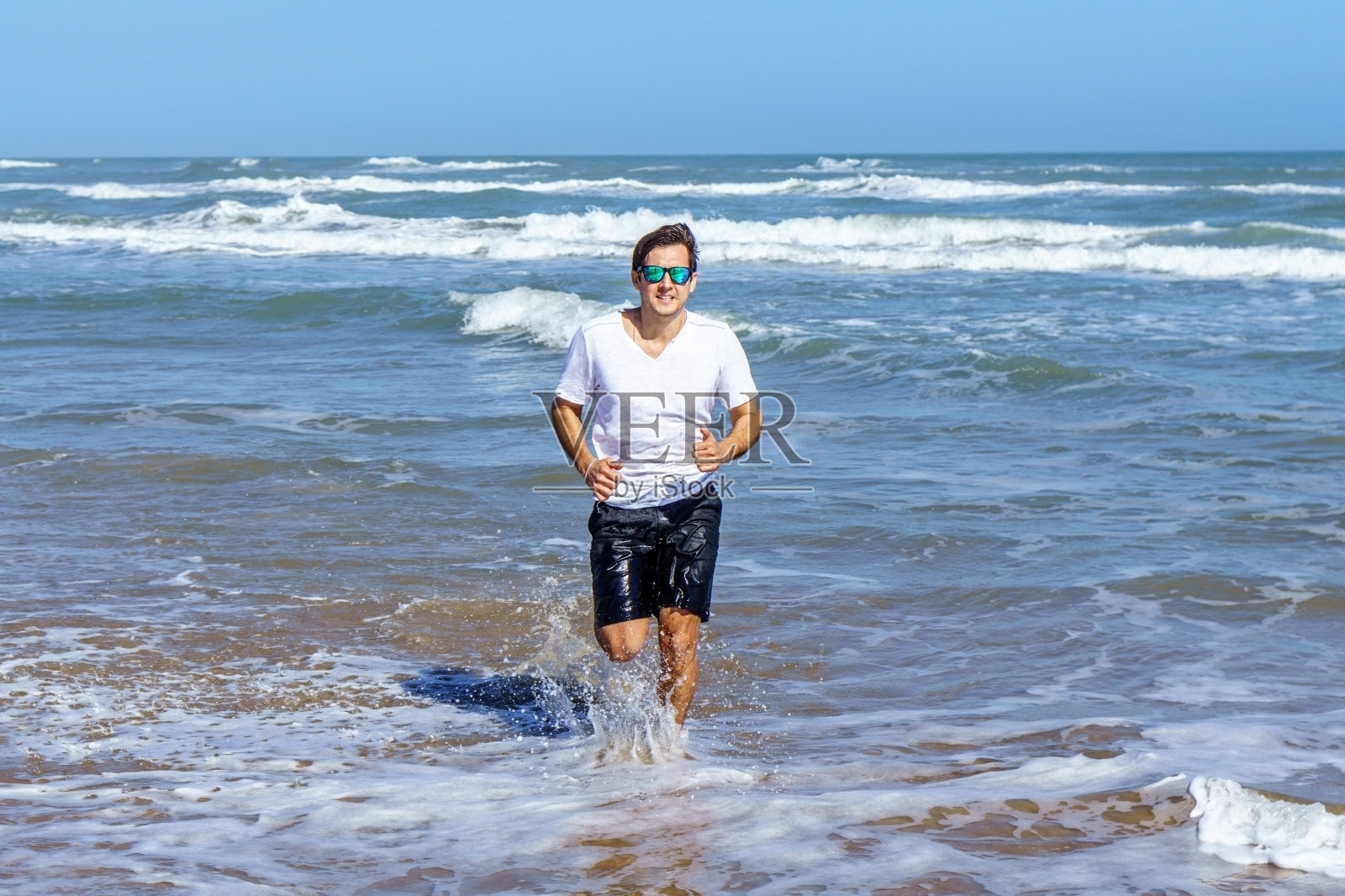 一名西班牙裔男子在海里奔跑照片摄影图片