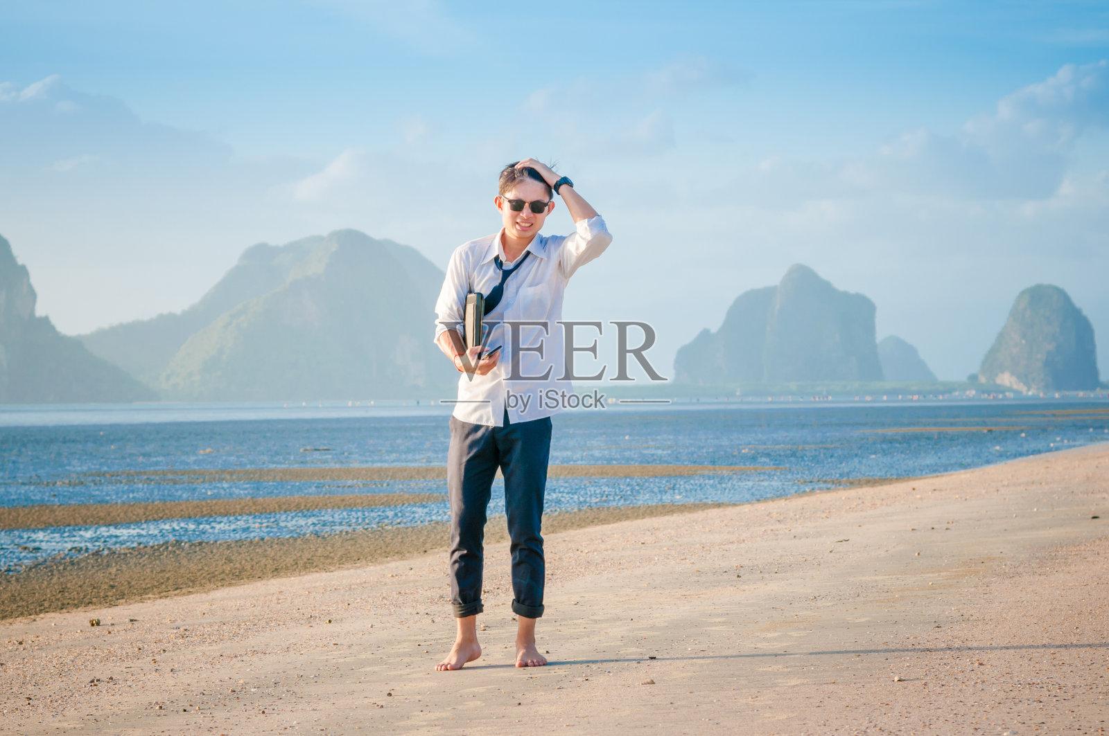 商人工作与笔记本电脑和智能手机的海滩背景照片摄影图片