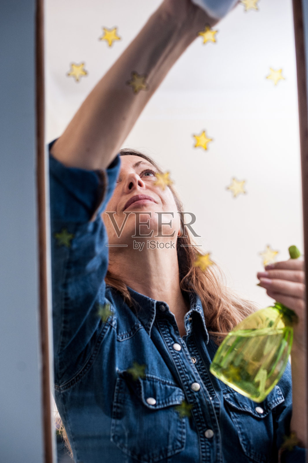 美丽的成年妇女清洁窗户-从外面看照片摄影图片