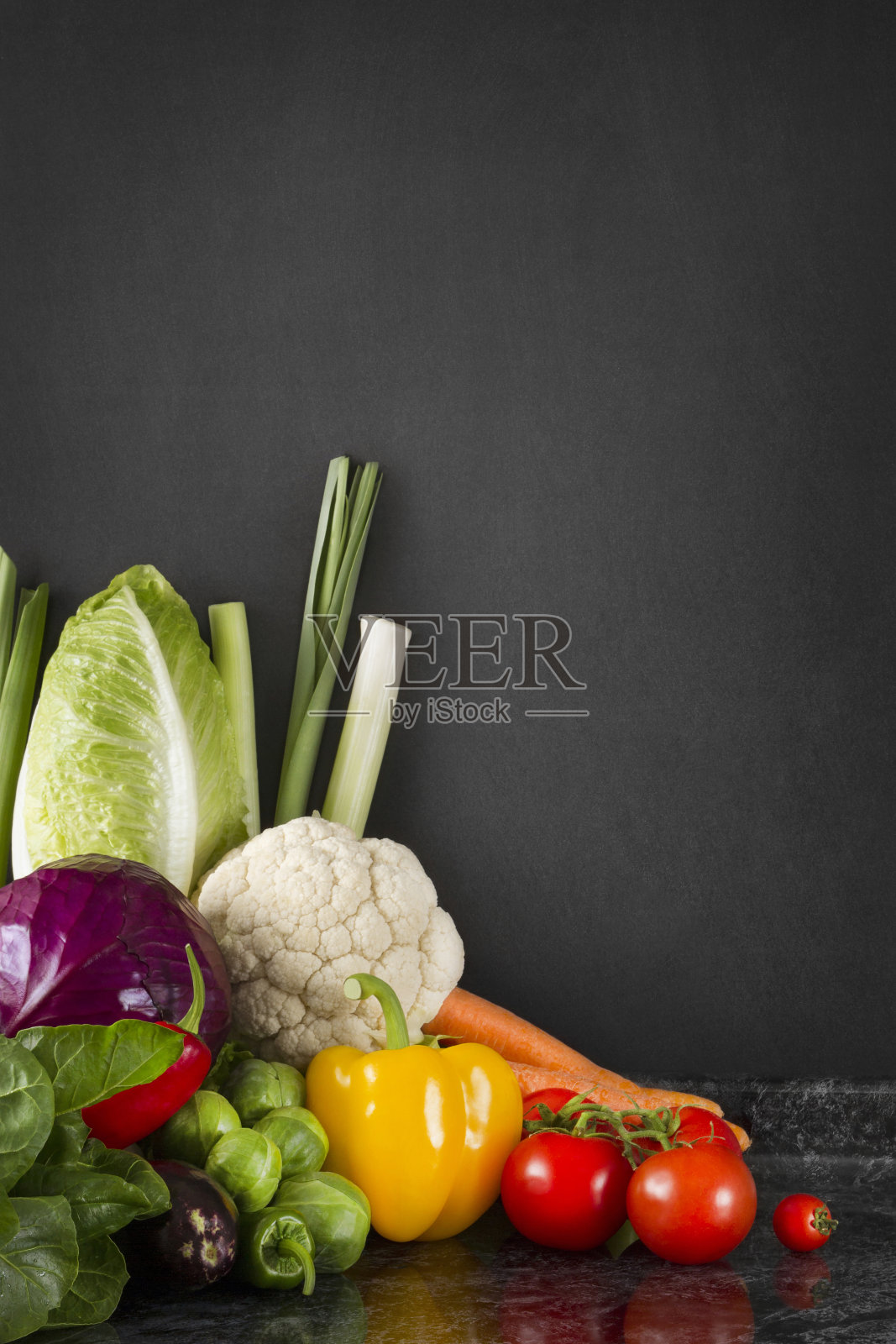 厨房台面上的新鲜蔬菜和黑板墙照片摄影图片