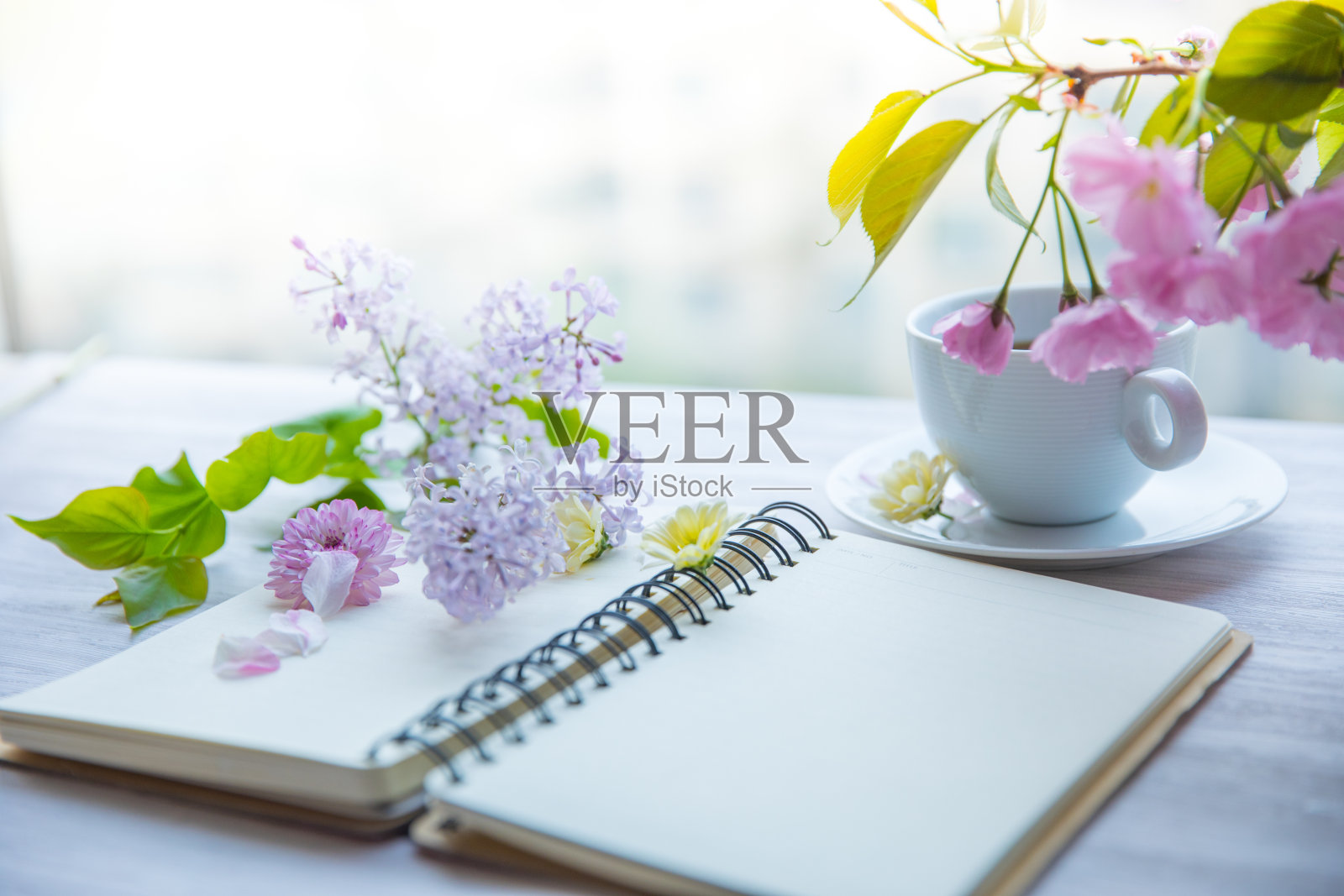 桌上放着鲜花和笔记本照片摄影图片