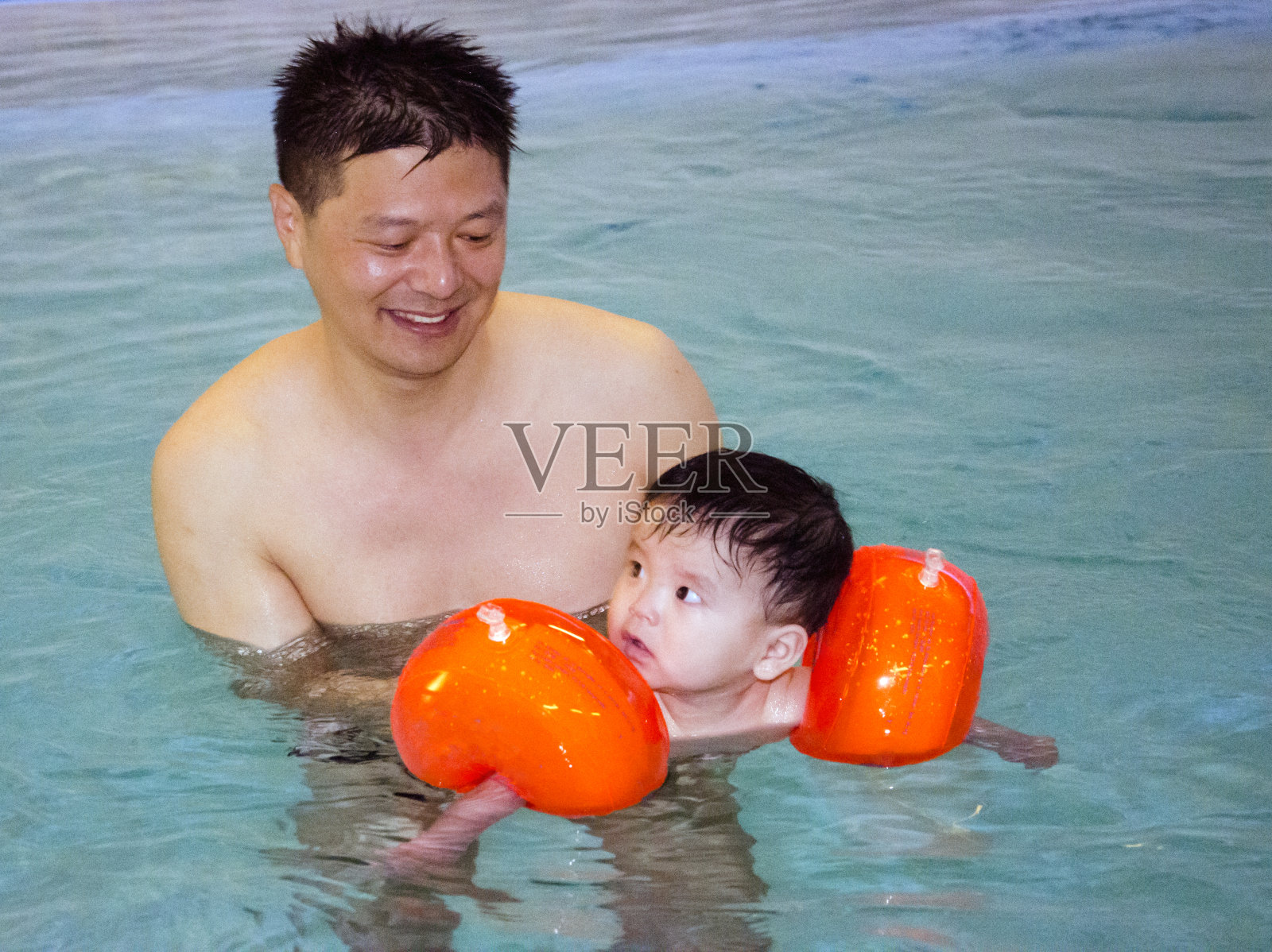 父亲教他的小儿子游泳照片摄影图片