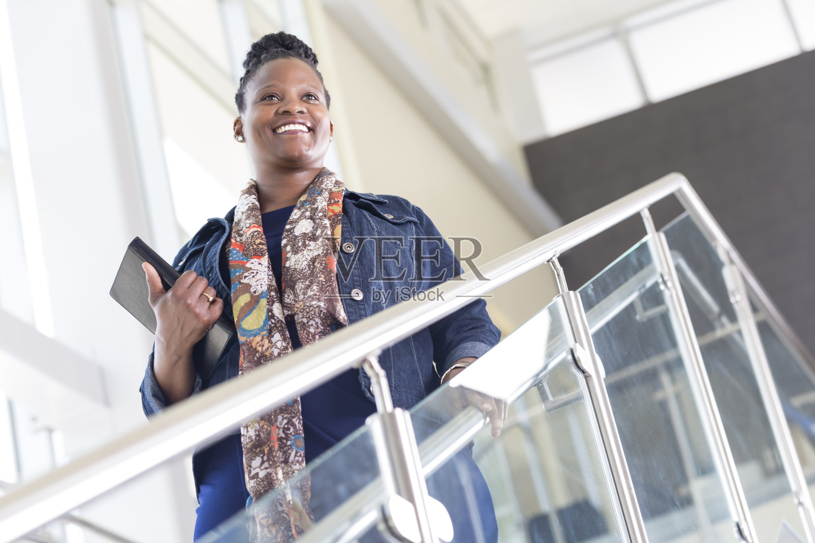 女商人在美丽的办公楼里走下楼梯照片摄影图片