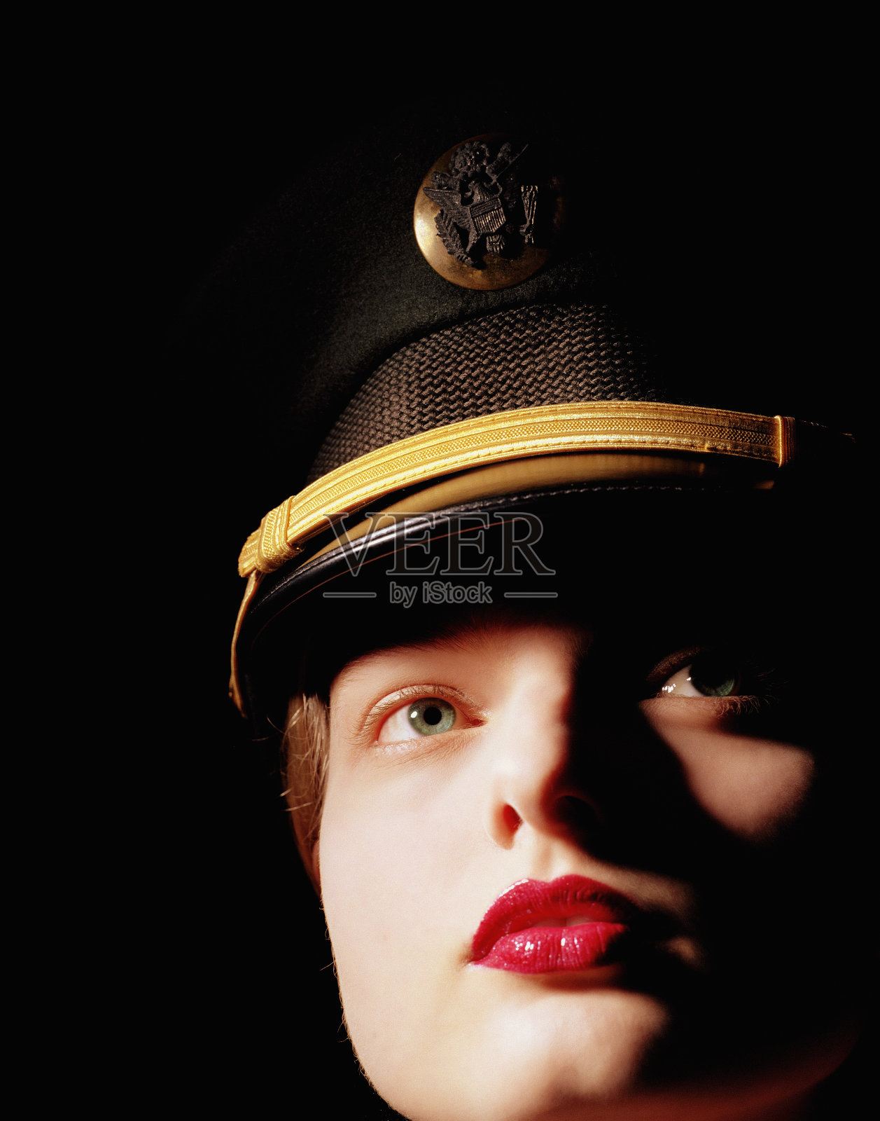 戴着军帽的年轻女子，看向别处，特写照片摄影图片